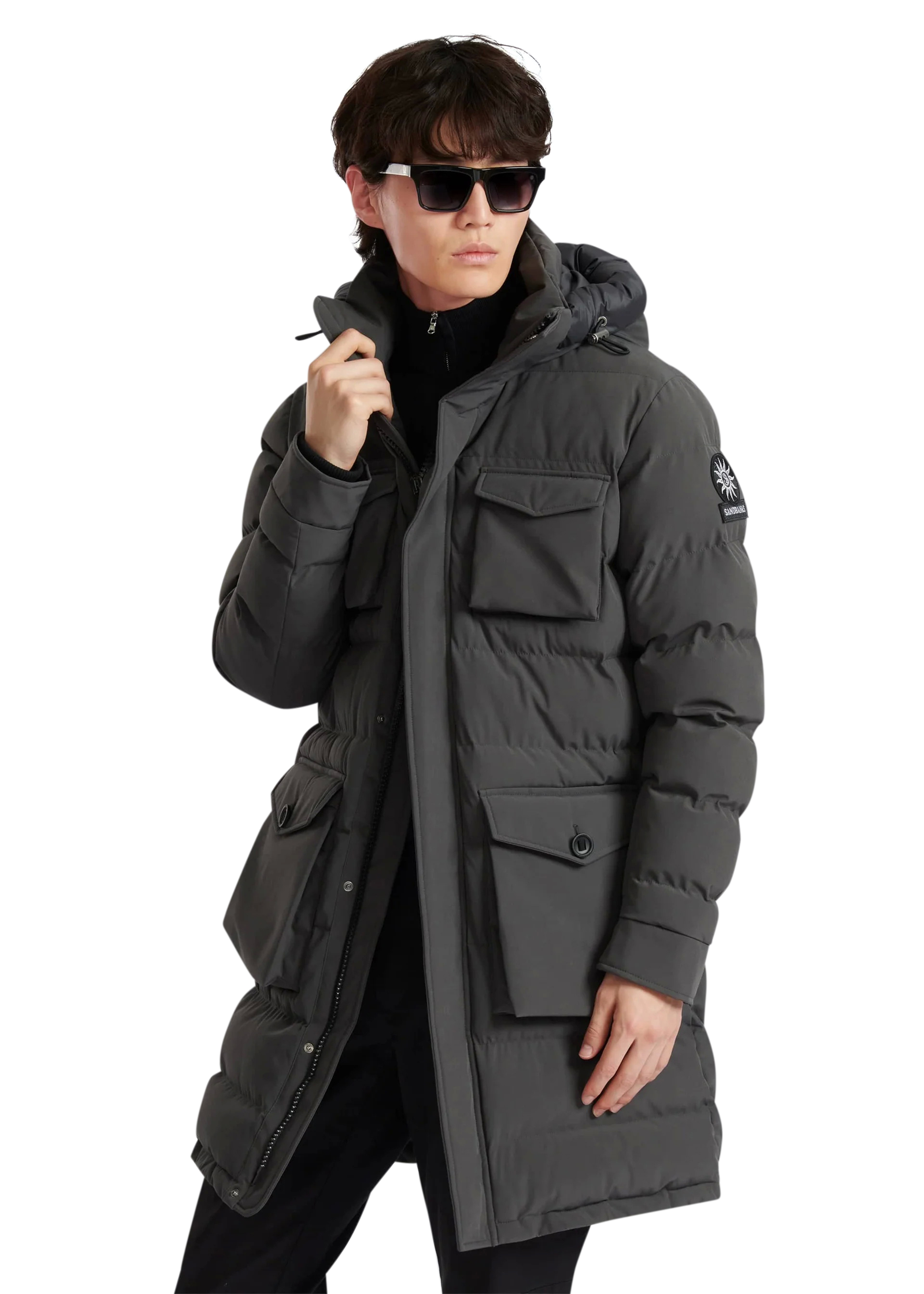 Person wearing a gray winter coat with a brand logo on a white background