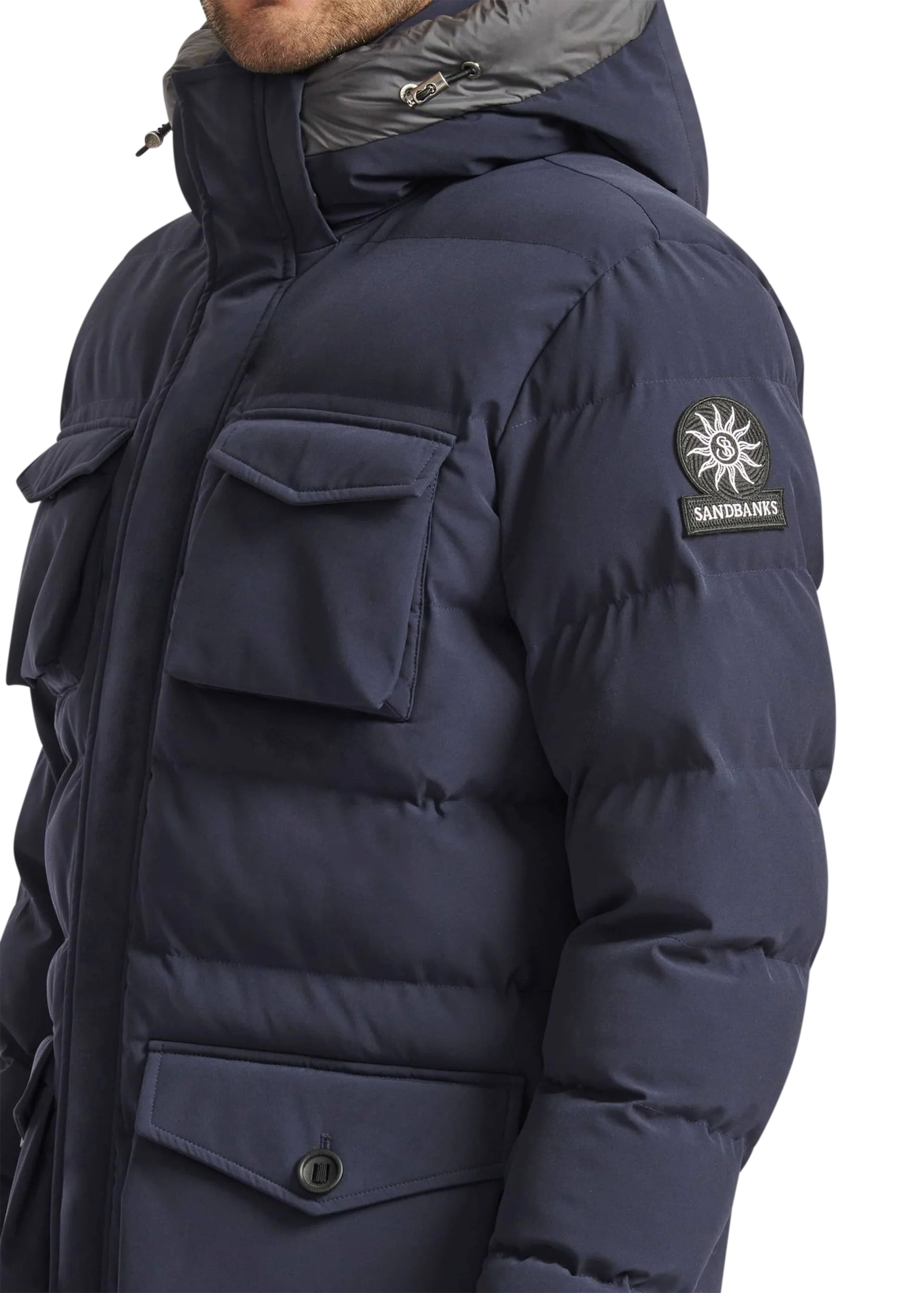 Navy blue winter jacket with a brand logo on the sleeve against a white background
