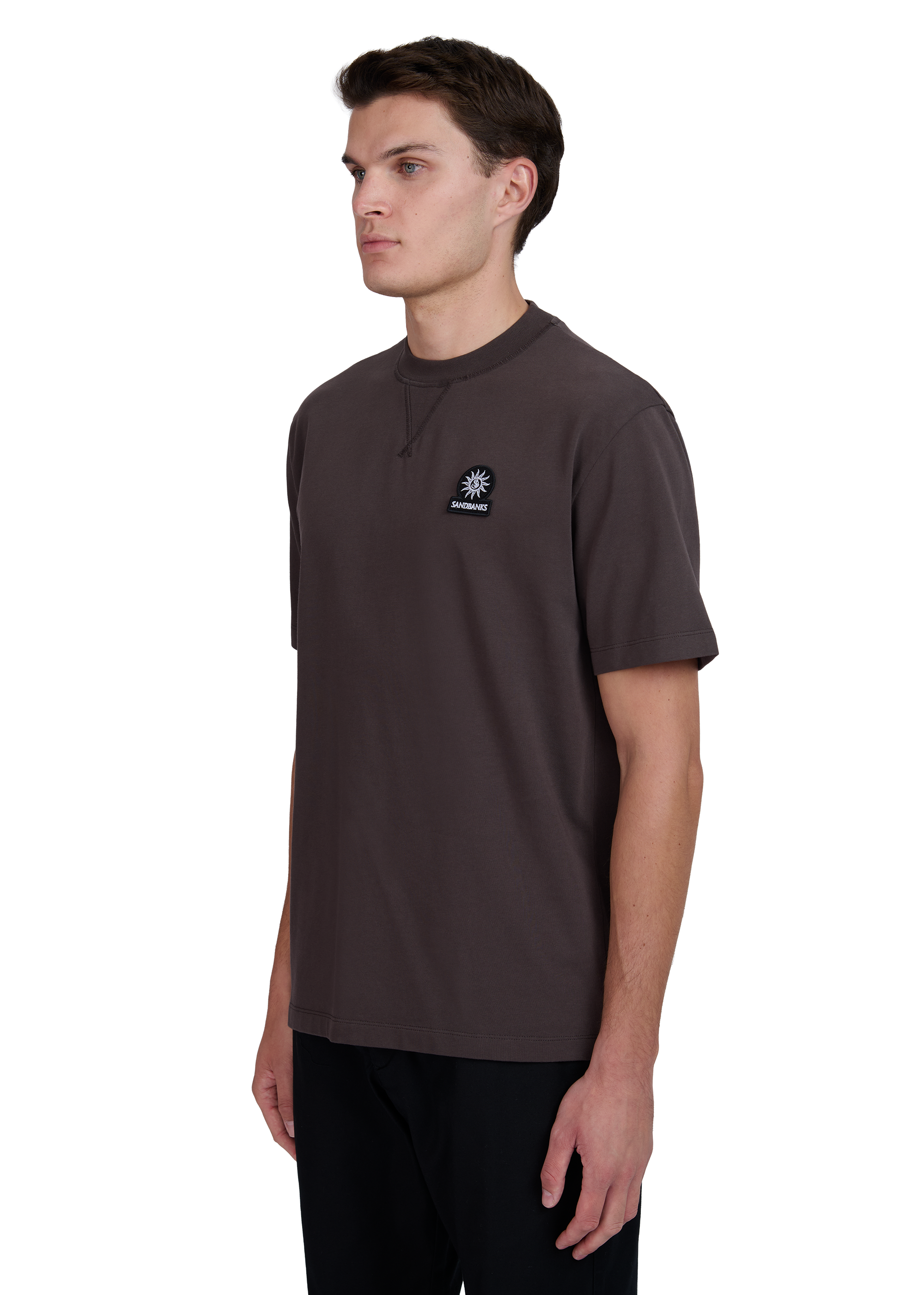 Model wearing a brown t-shirt with a logo on a white background