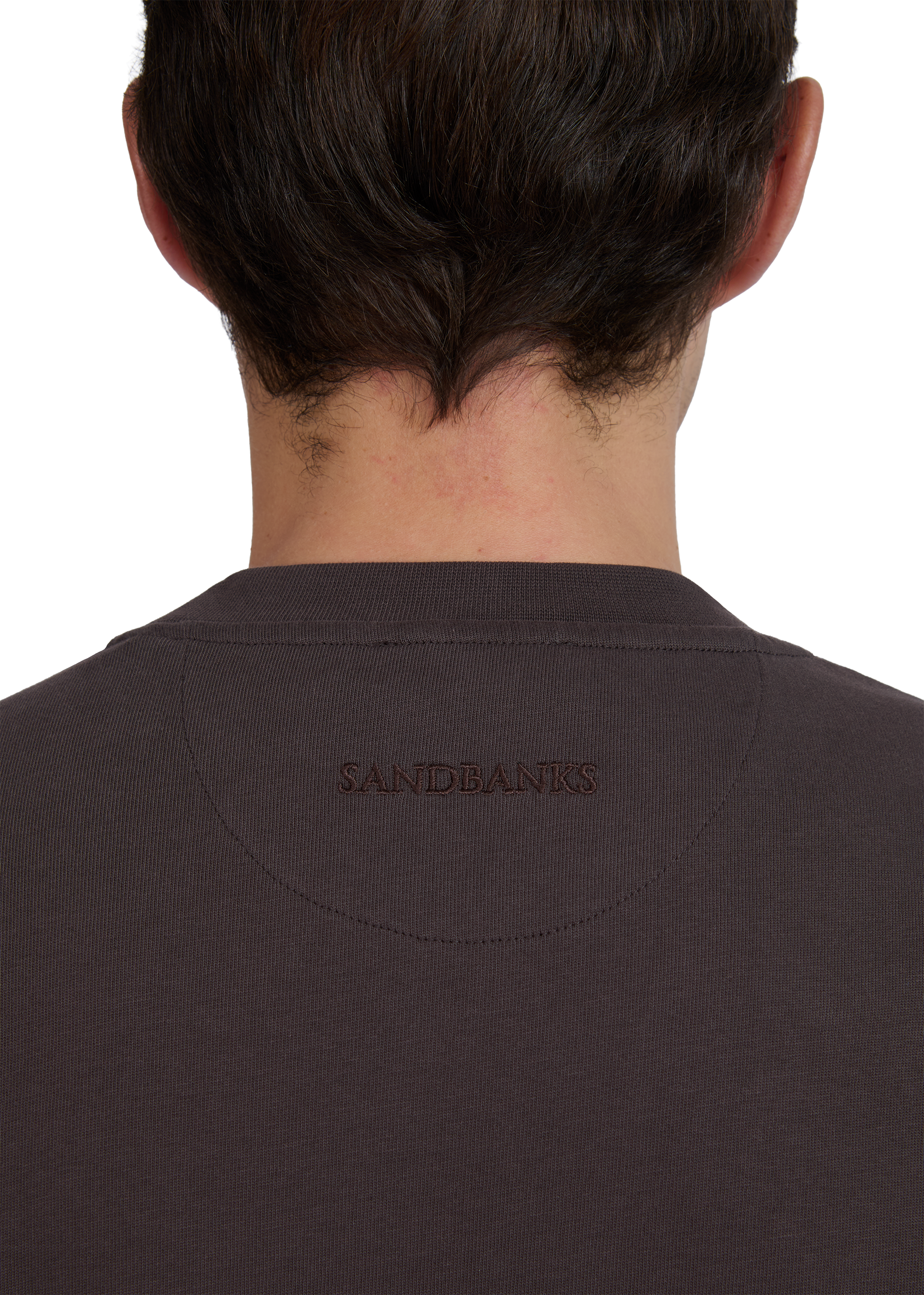 Back view of a model wearing a brown t-shirt with 'Sandbanks' branding.