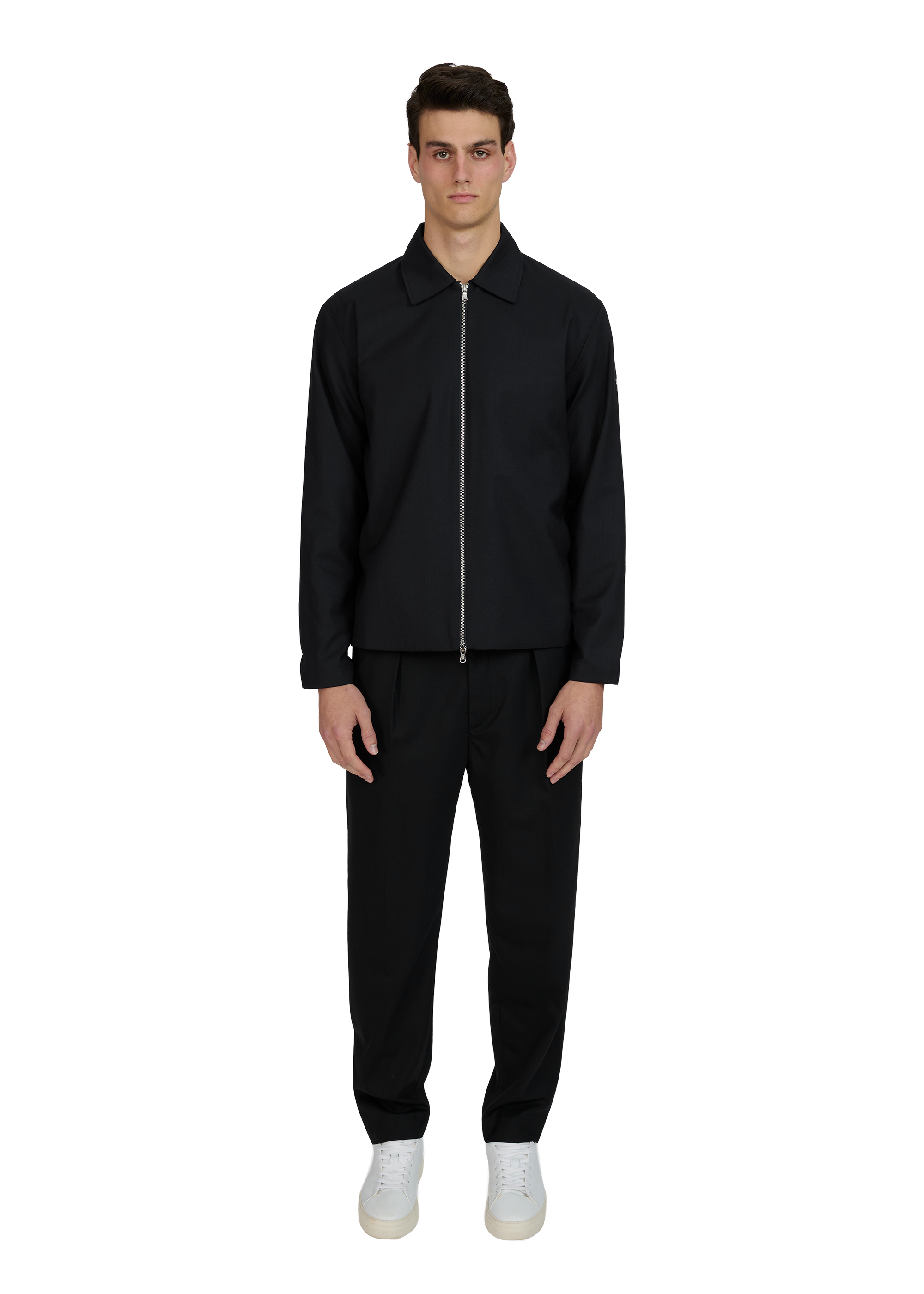 Man wearing a black jacket and pants on a white background