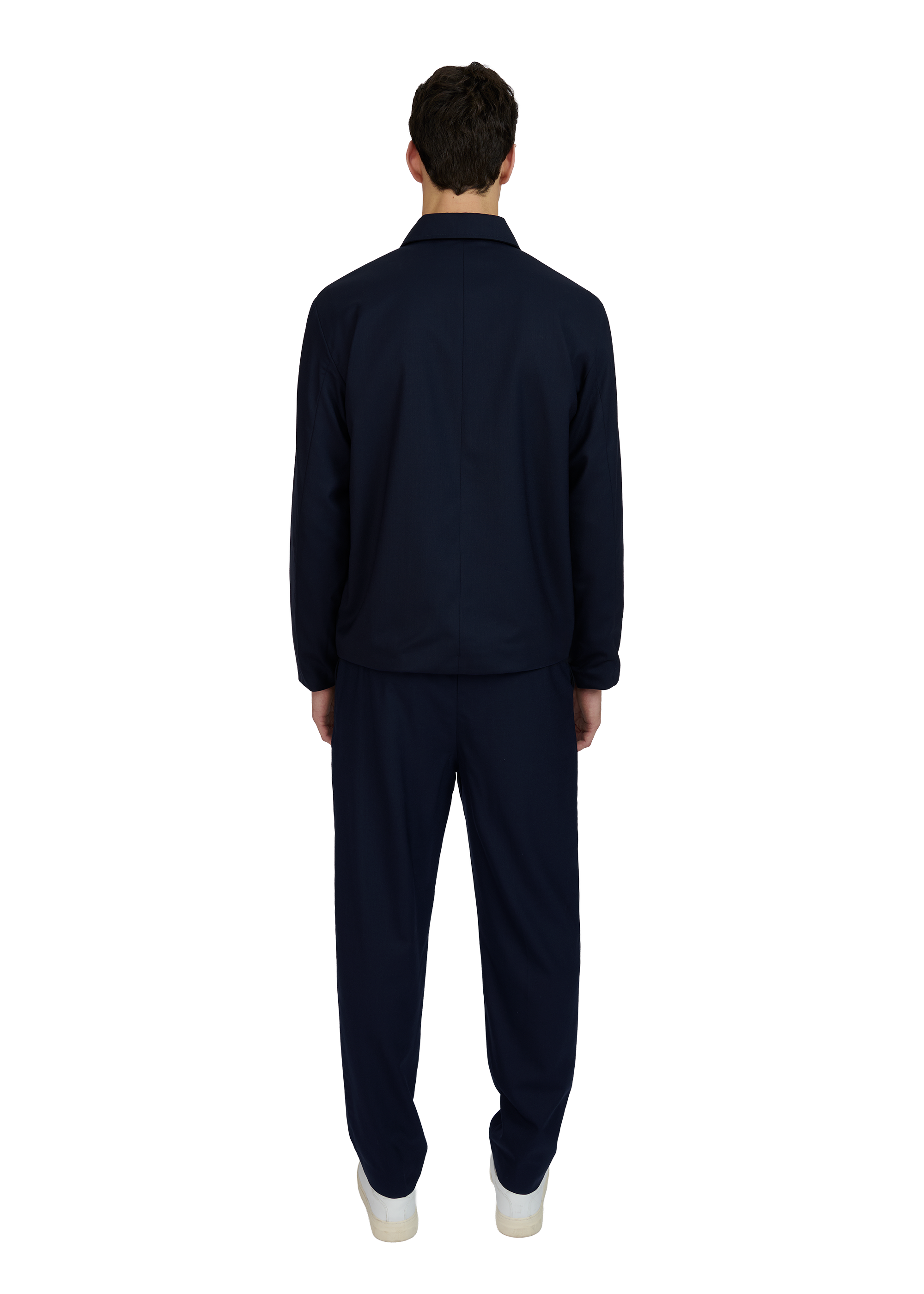 Person wearing a navy tracksuit on a white background