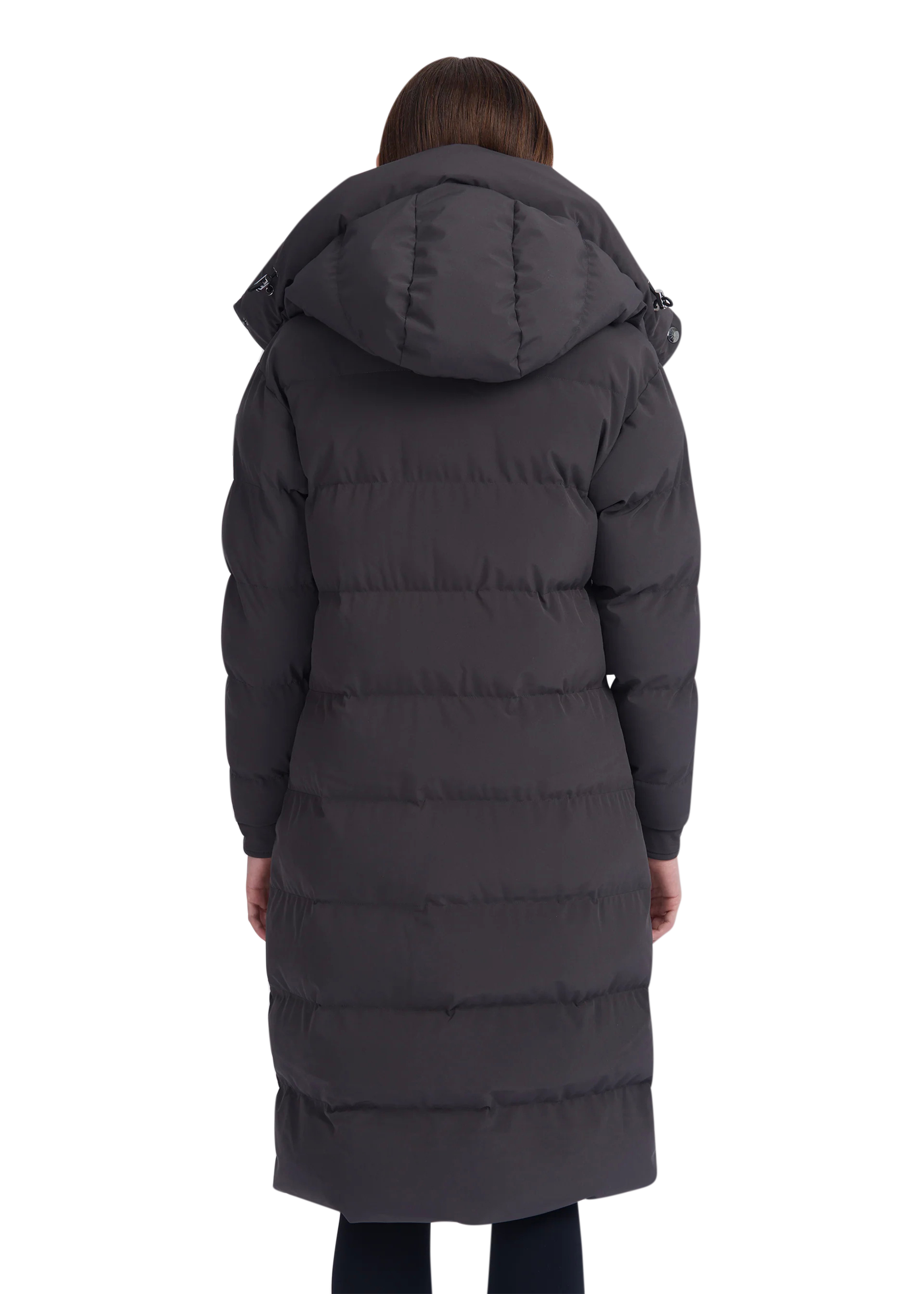 Person wearing a long dark gray puffer coat with a hood on a white background