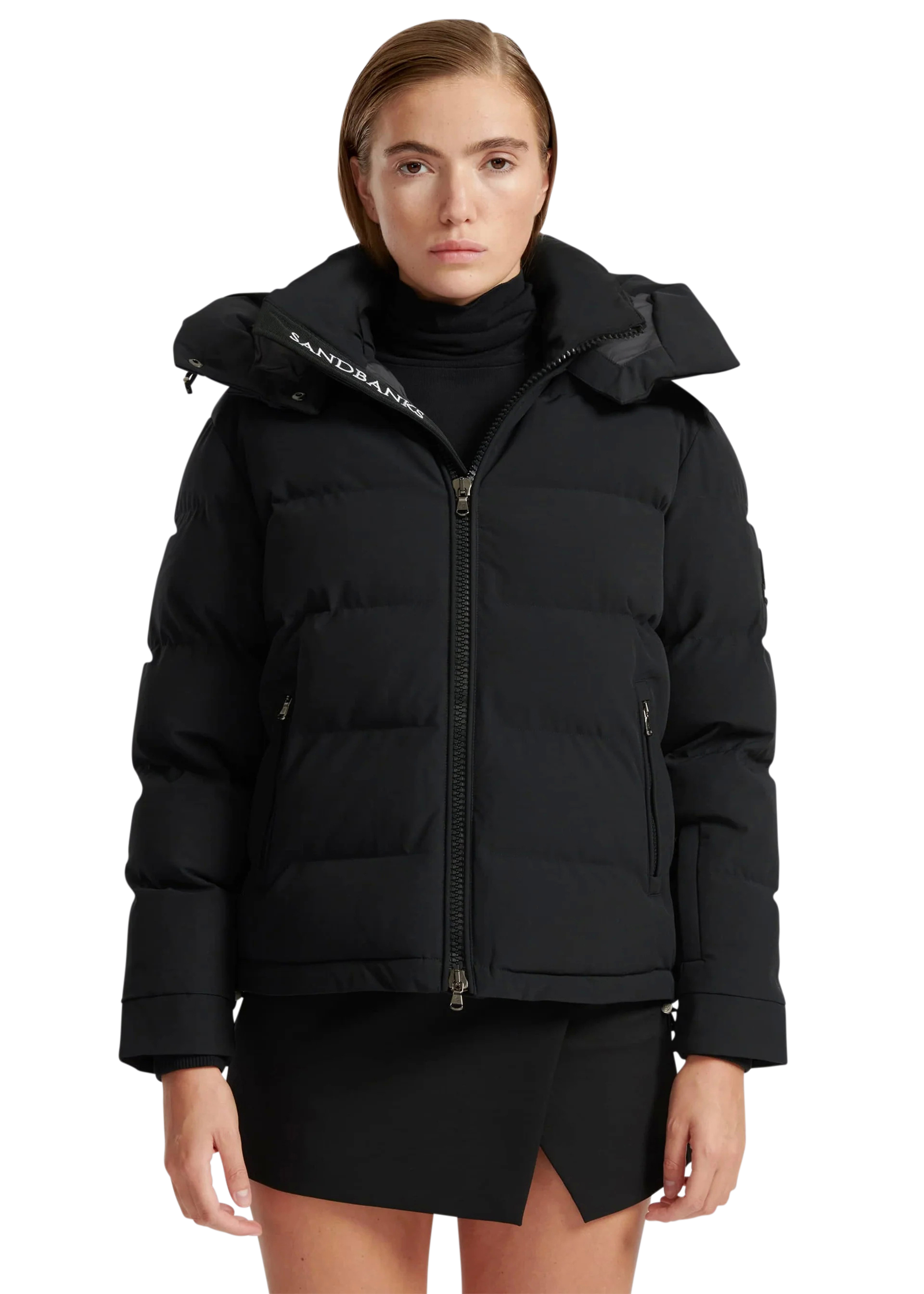 Woman wearing a black puffer jacket with a brand logo on a white background
