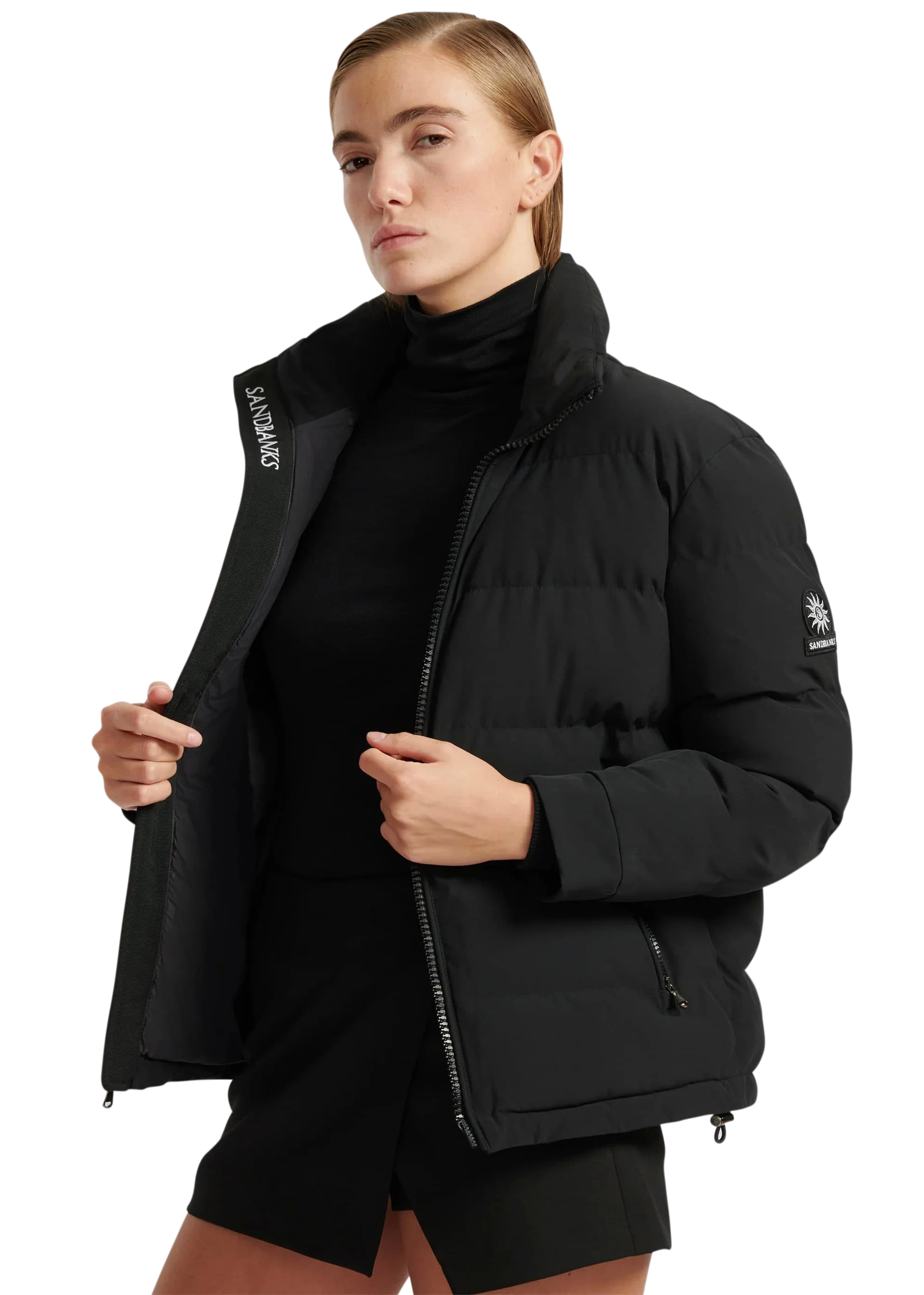 Person wearing a black puffer jacket with a brand logo on a white background