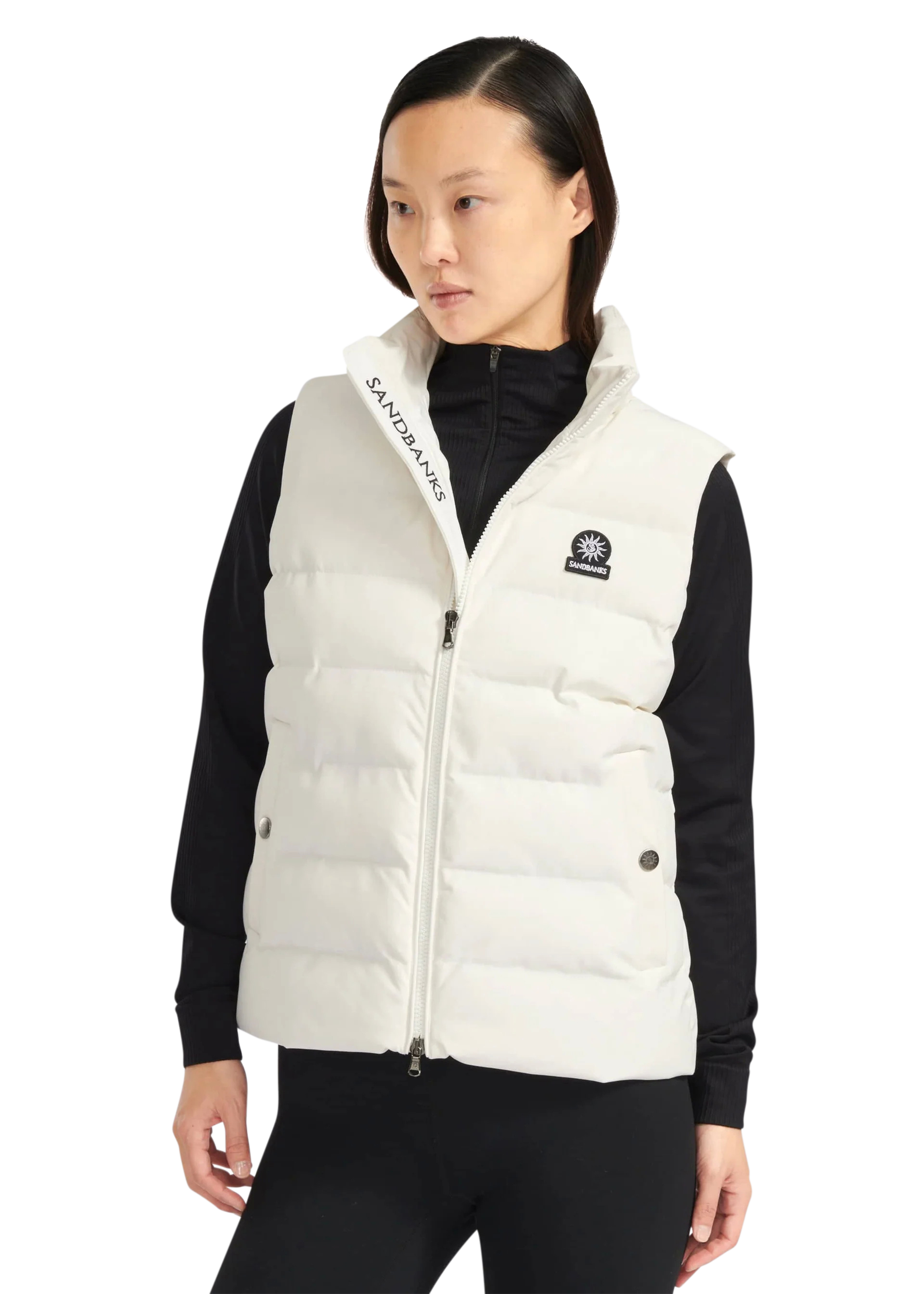 Woman wearing a white puffer vest with brand logos on a white background