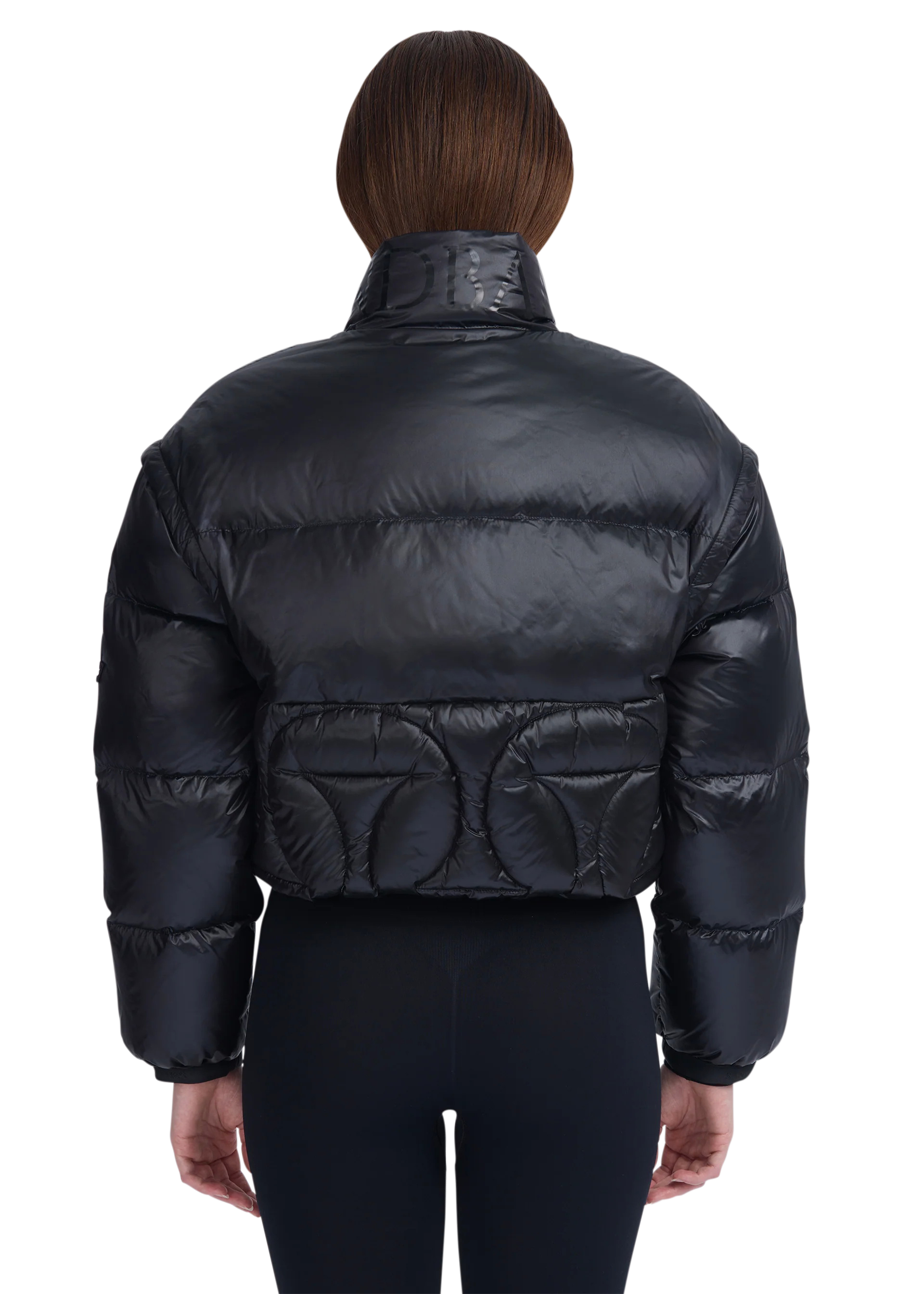 Black puffer jacket worn by a person on a white background