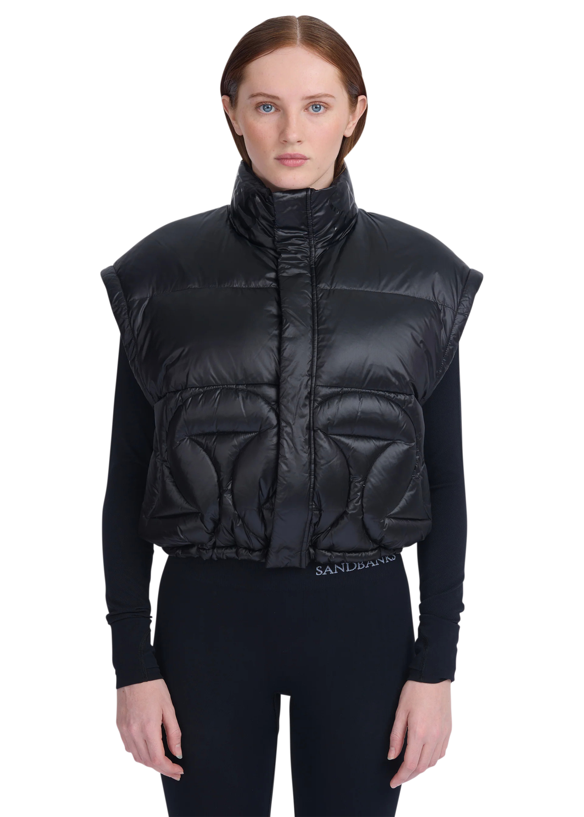 Woman wearing a black puffer vest with a brand logo on a white background