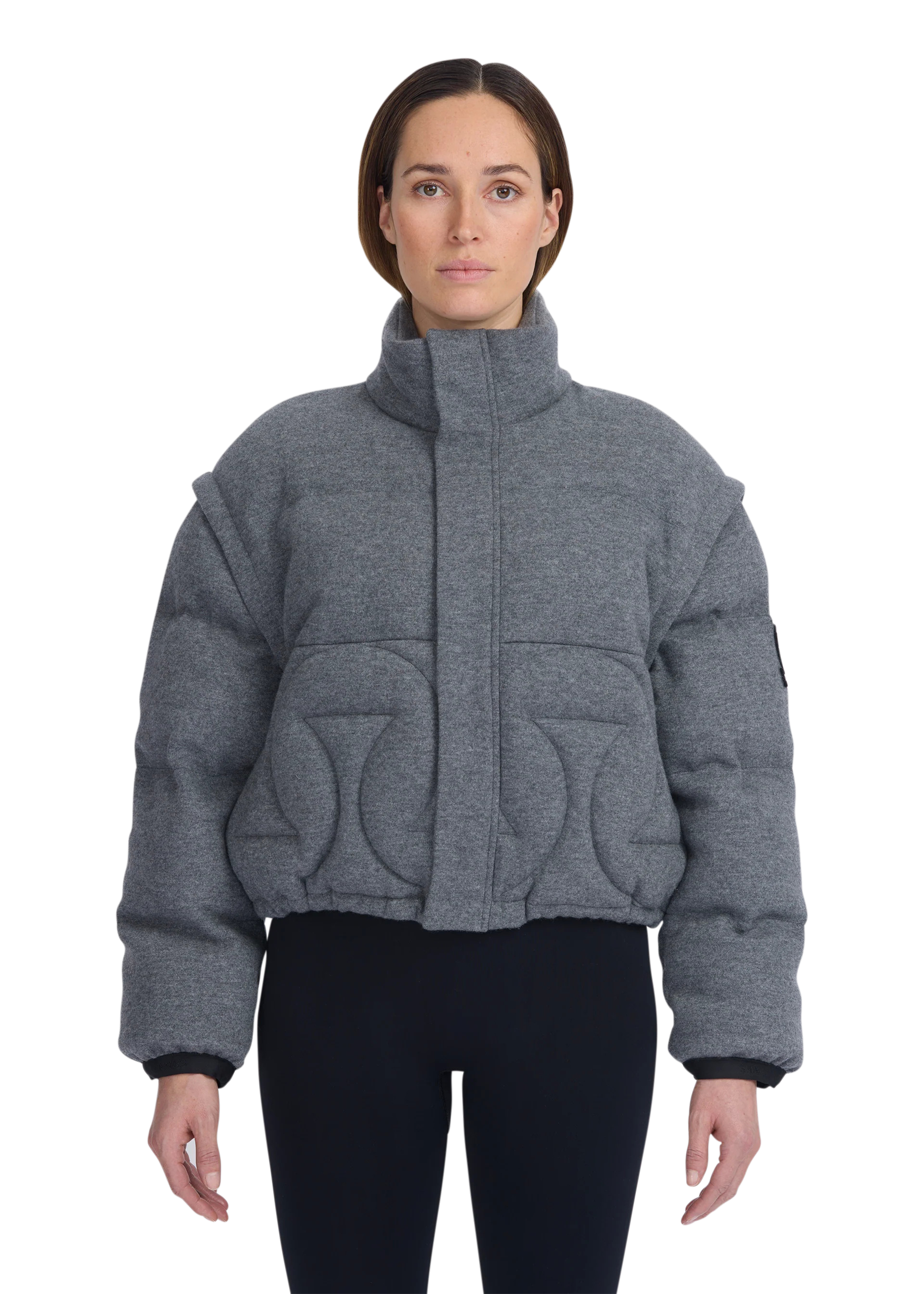 Person wearing a gray quilted jacket on a white background