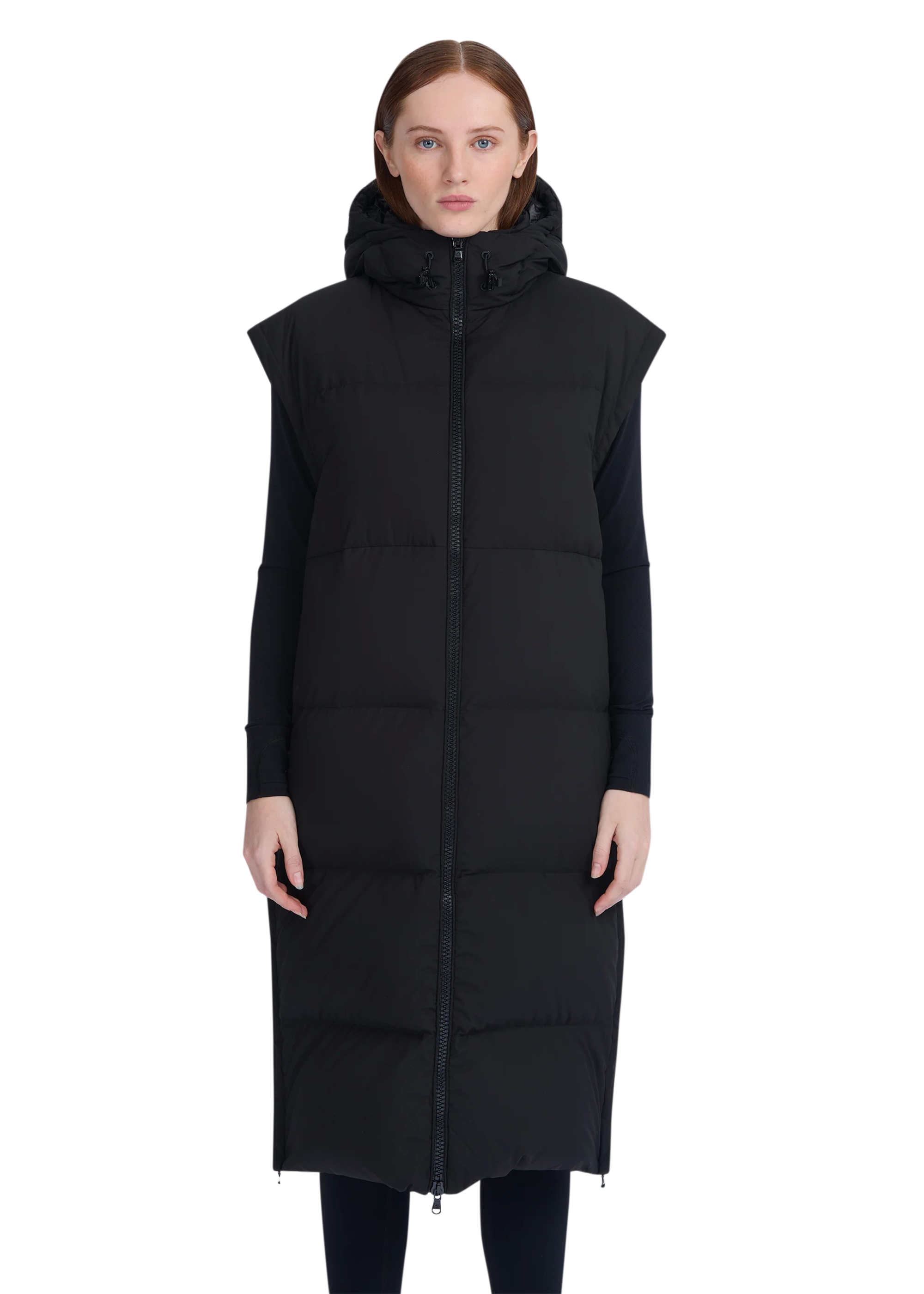 Woman wearing a long black puffer vest on a white background
