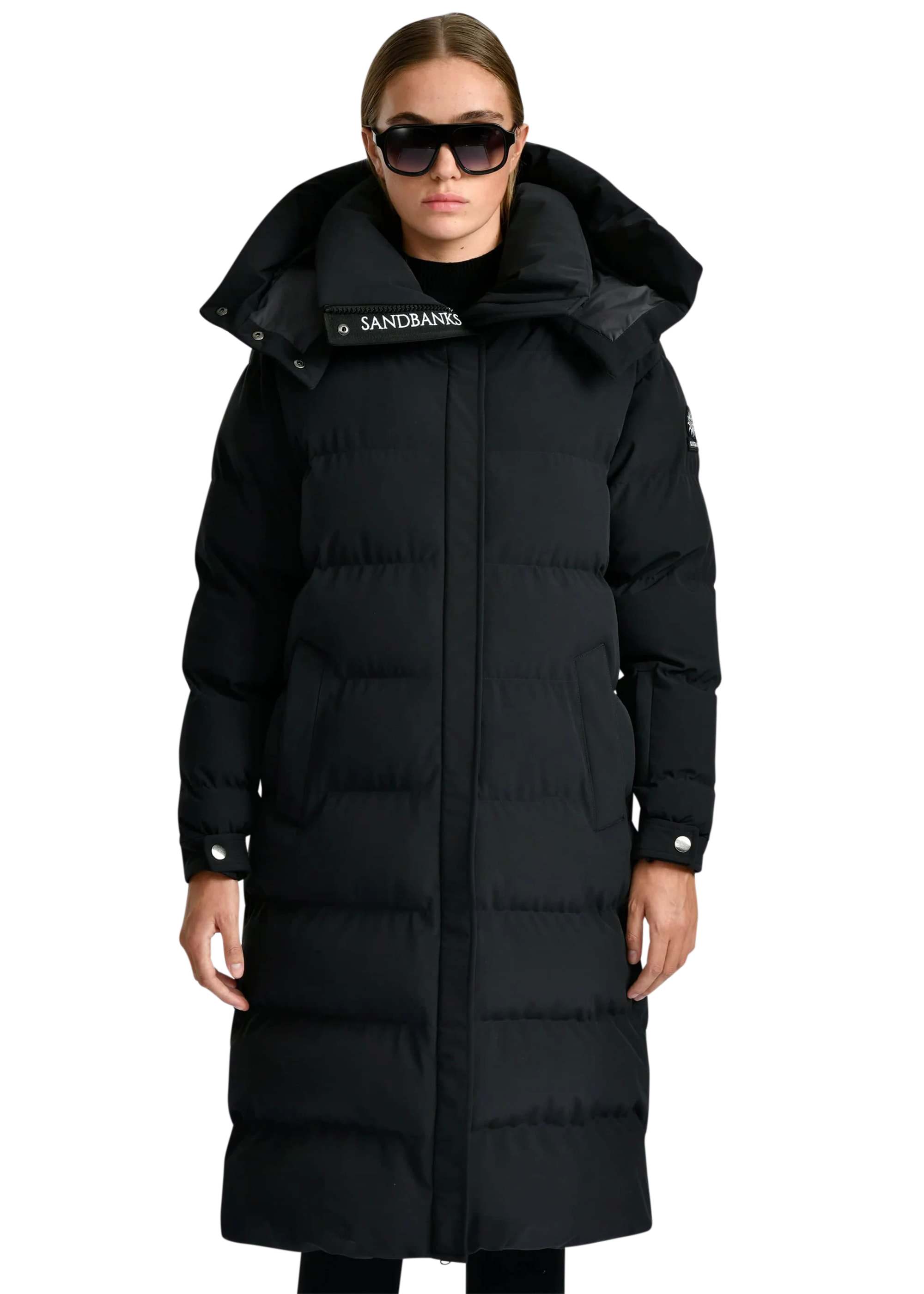 Person wearing a black puffer coat with a brand logo on a white background