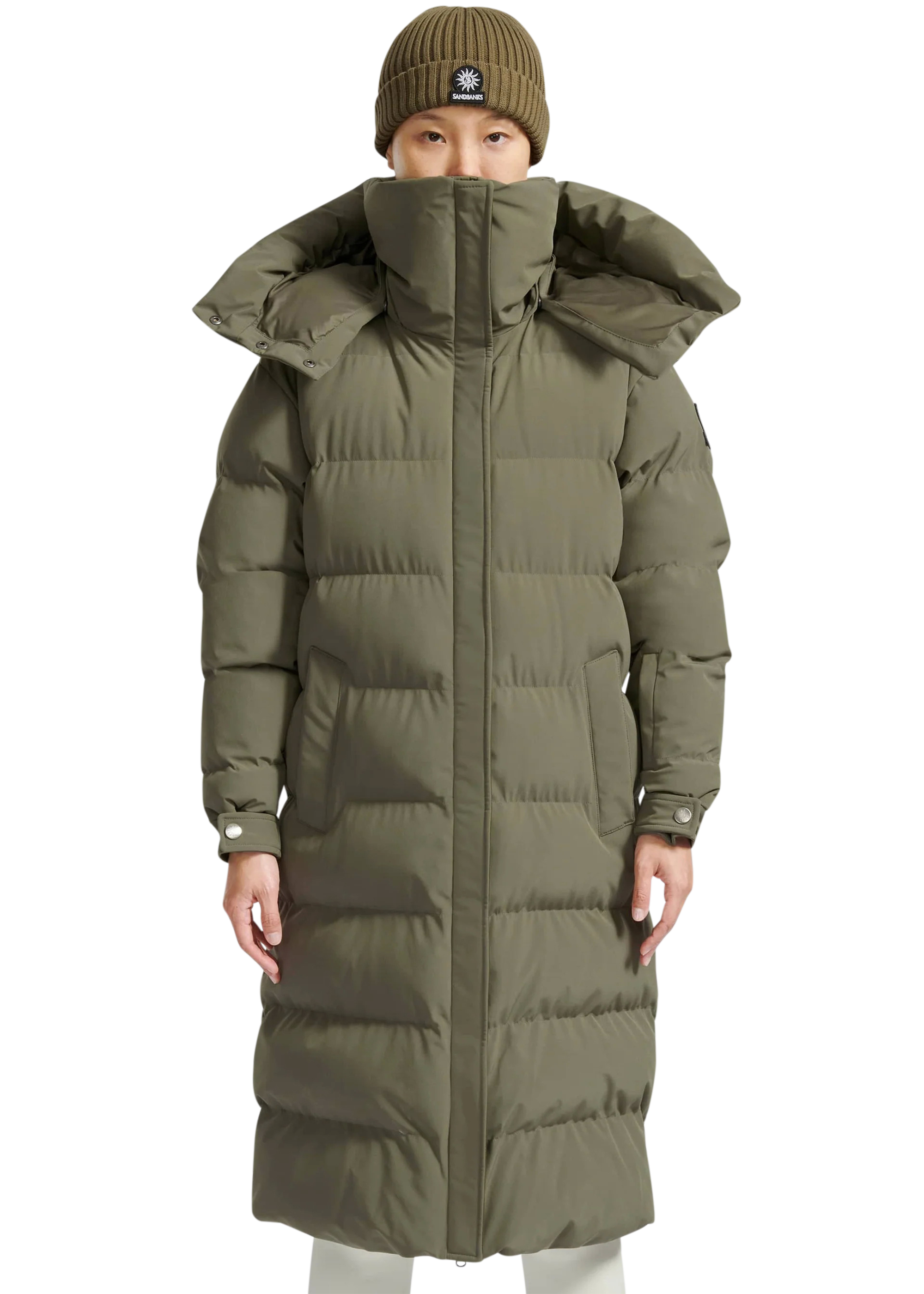 Person wearing a long olive green puffer coat on a white background