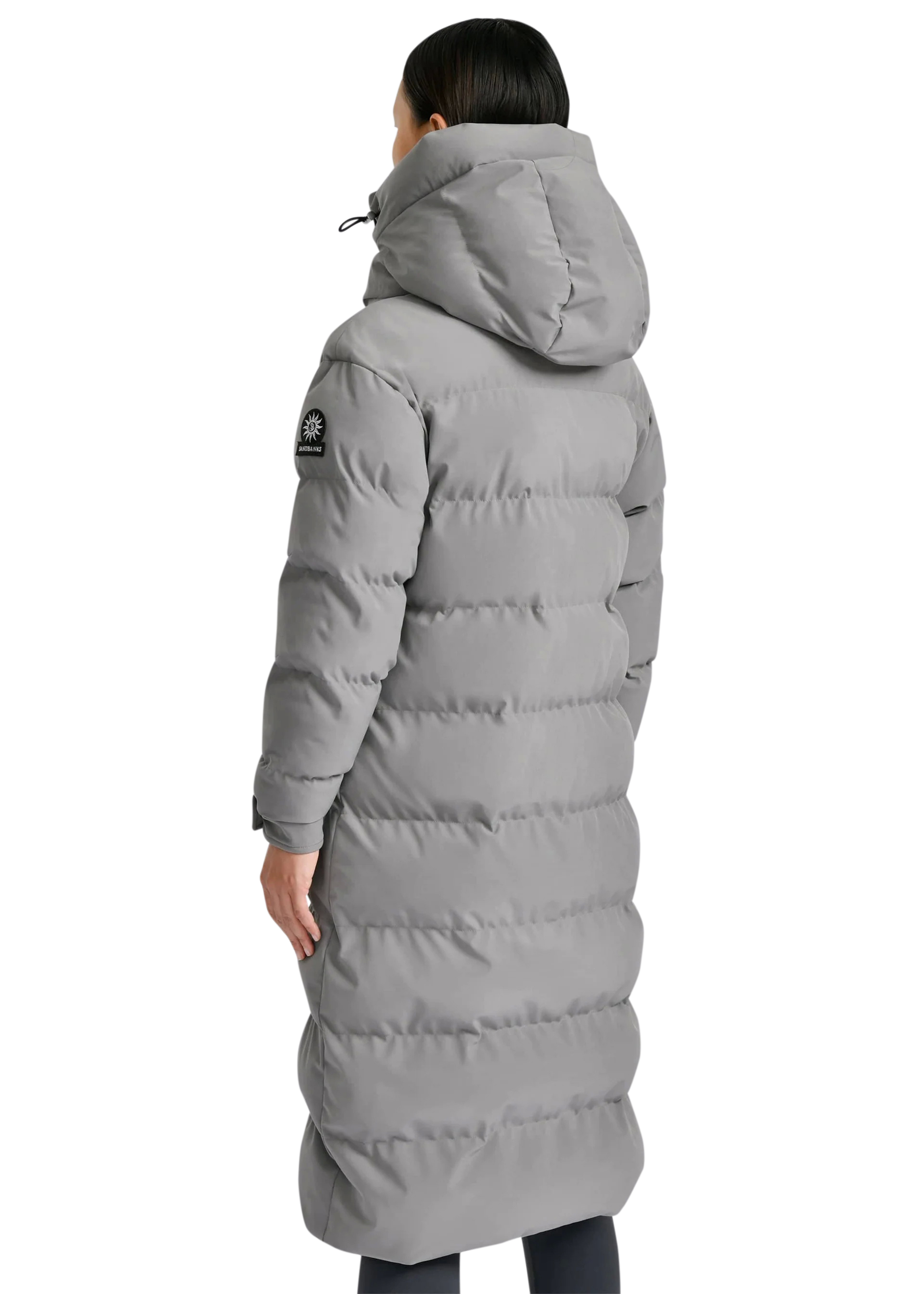 Person wearing a long gray puffer coat on a white background