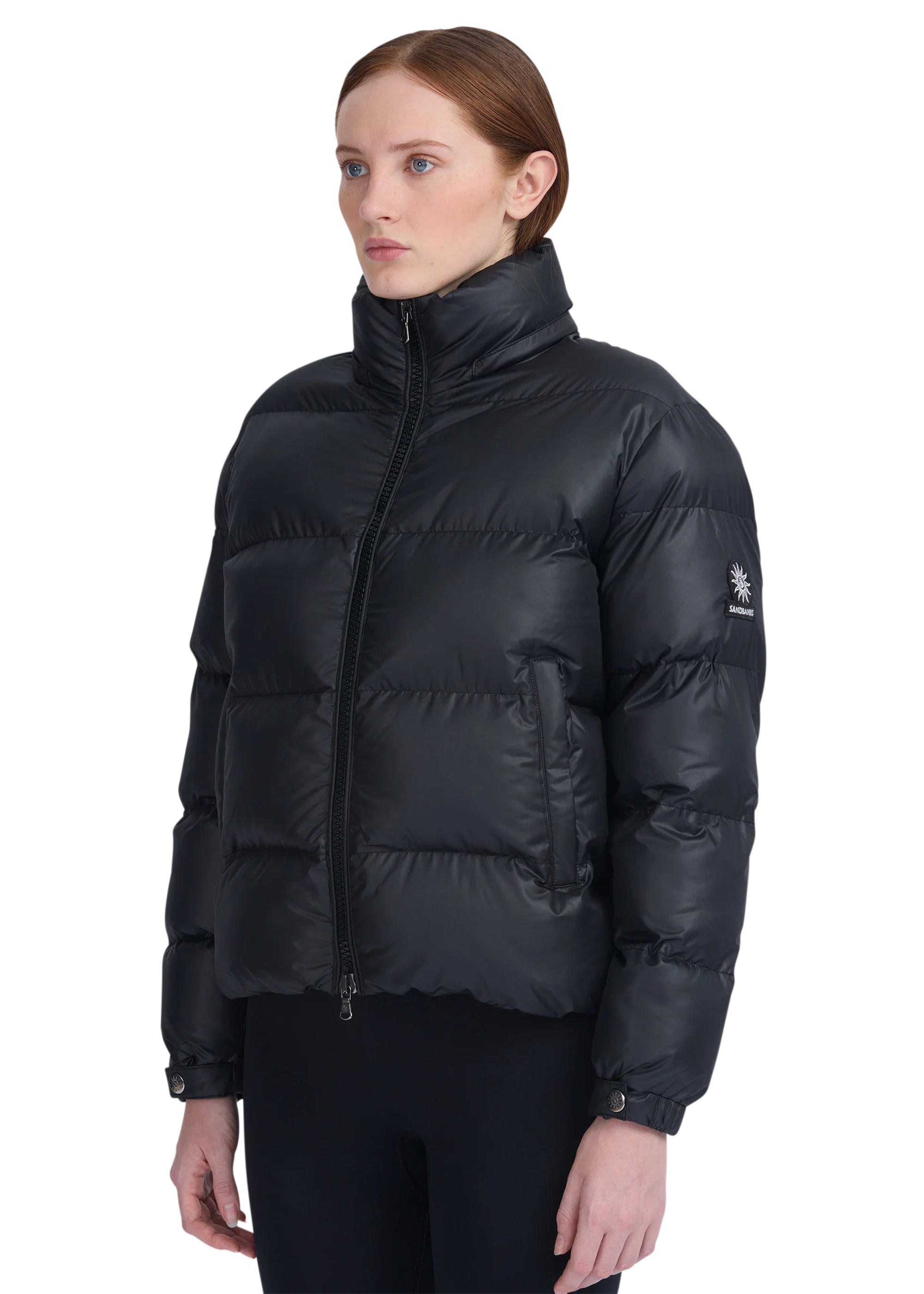 Woman wearing a black puffer jacket on a white background