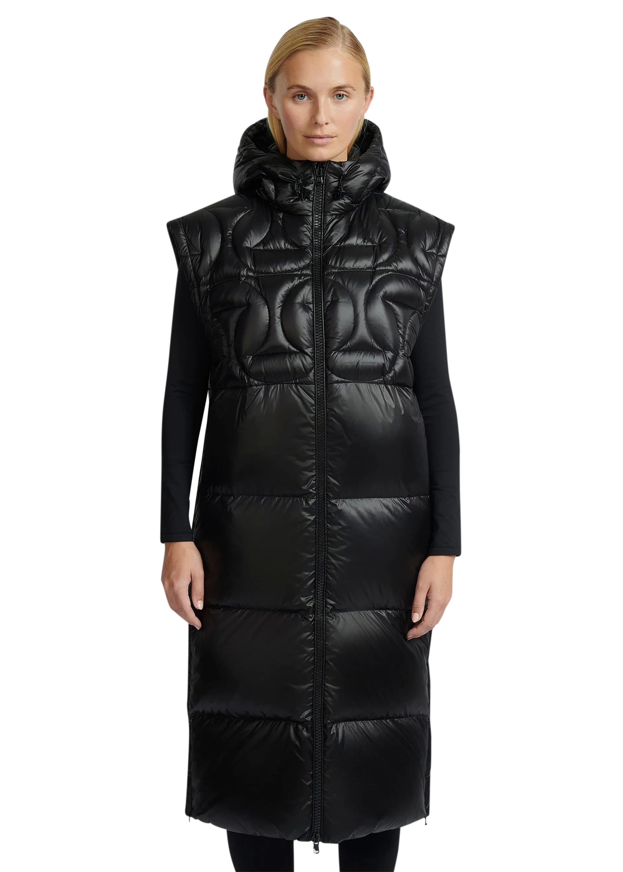 Woman wearing a long black quilted vest on a white background