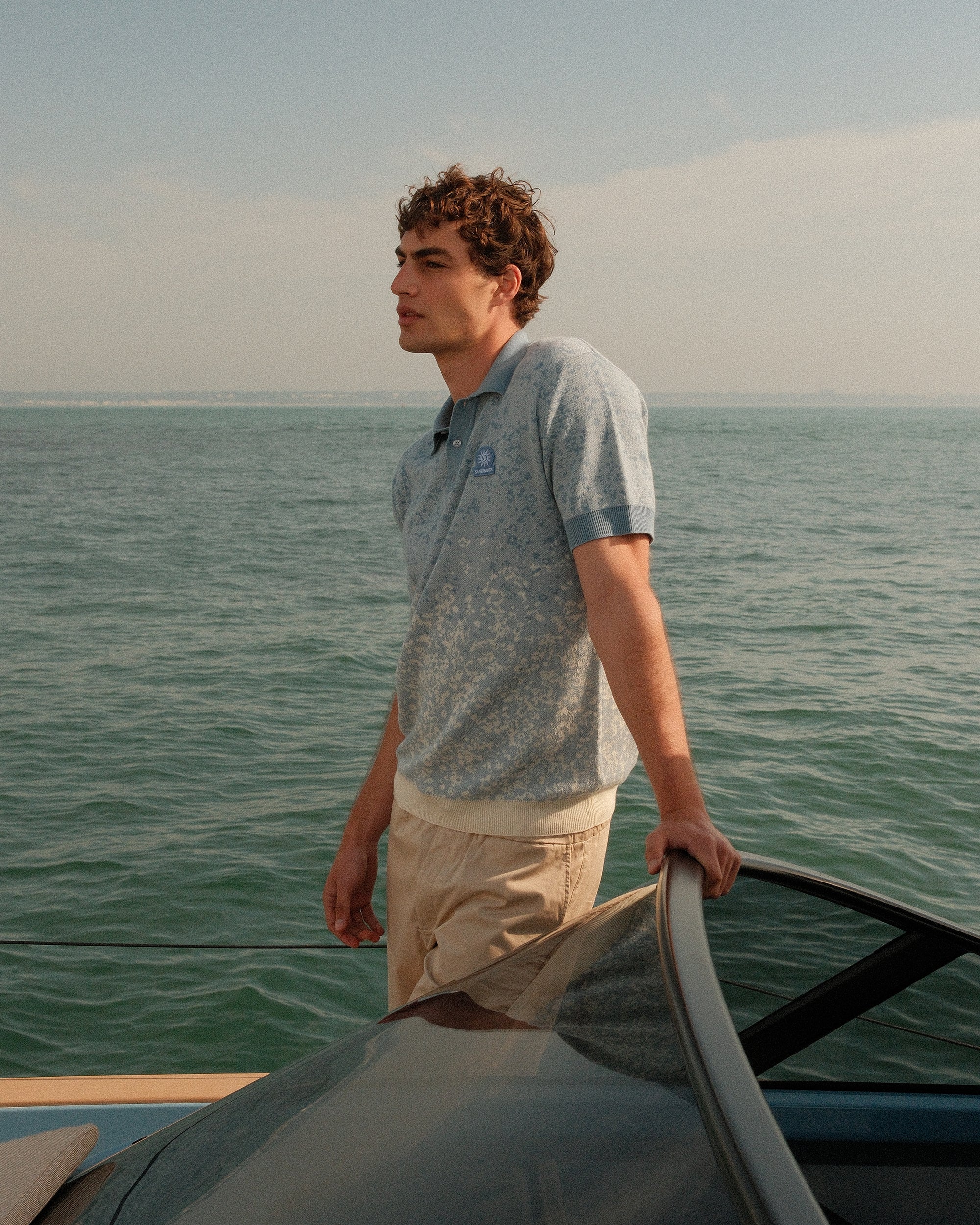 Man standing on a boat in the middle of a body of water