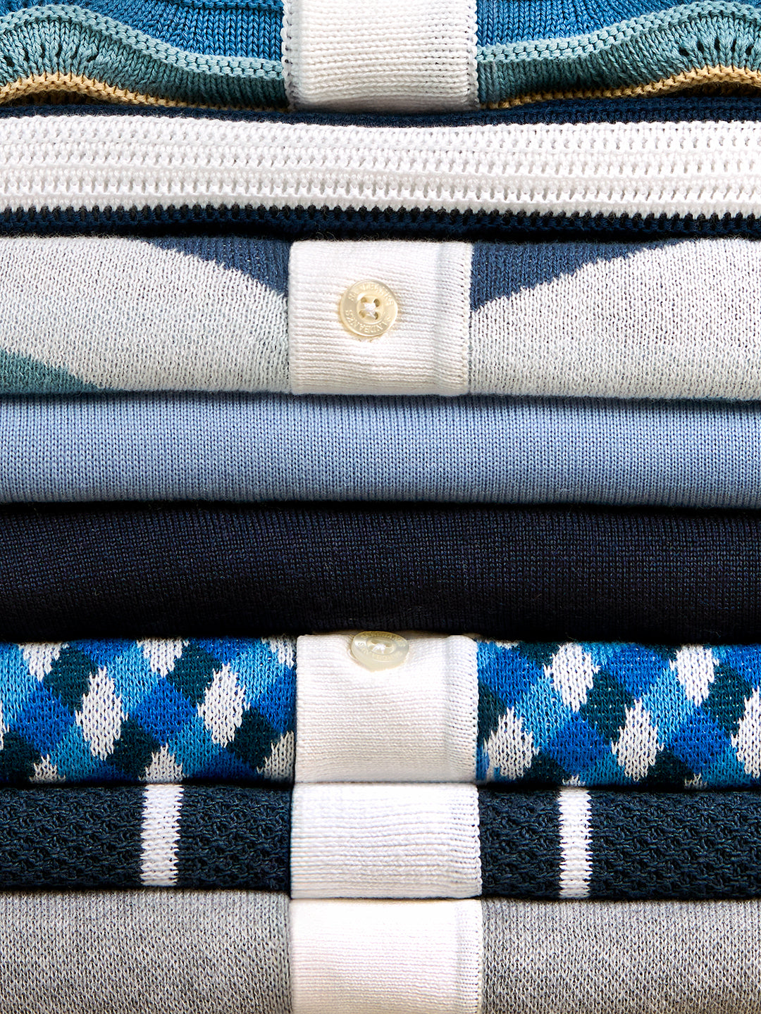 Stack of folded shirts in various patterns and colors