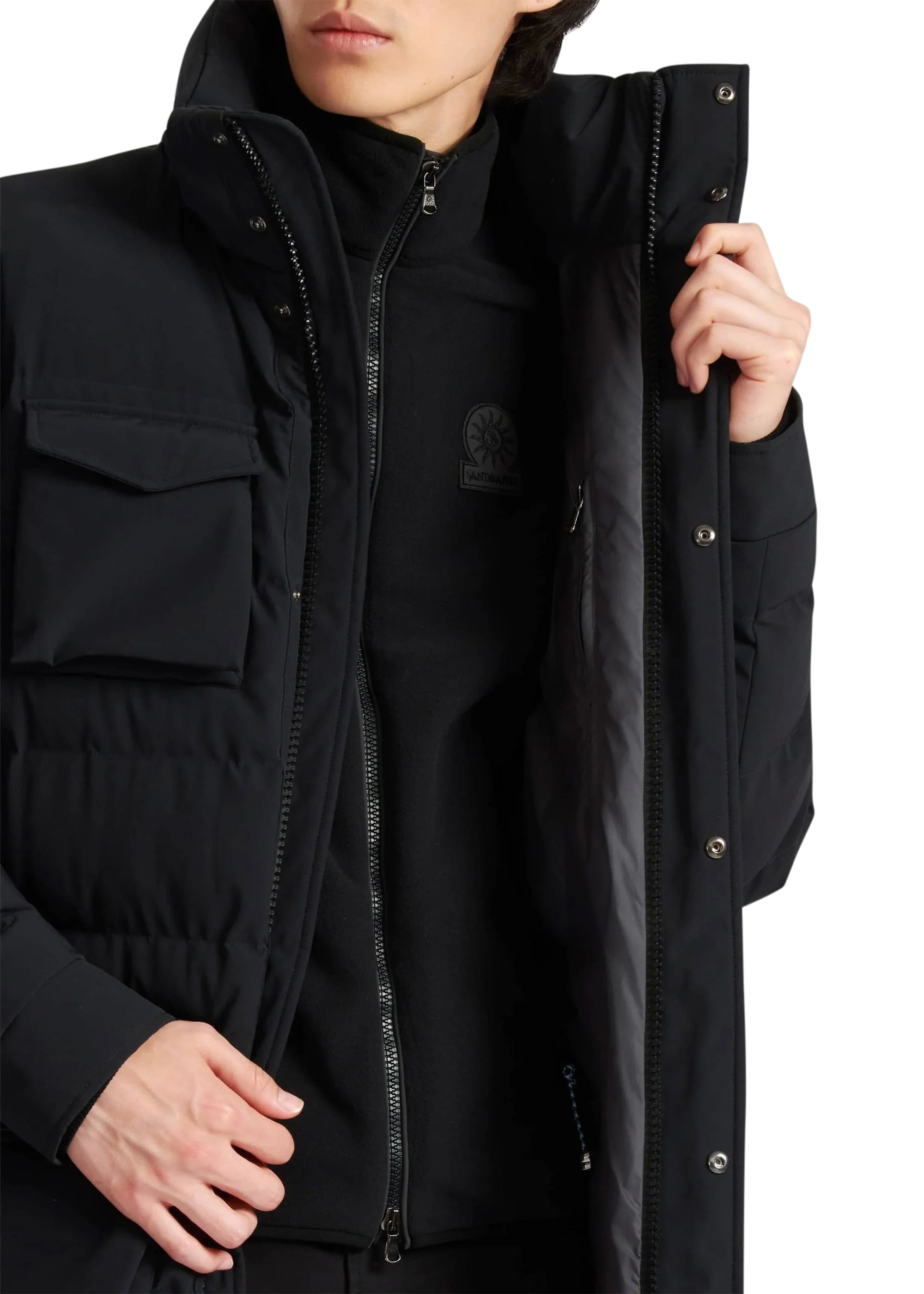 Person wearing a black jacket with a brand logo on a white background