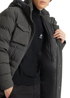 Person wearing a black puffer jacket over a black hoodie with a logo.