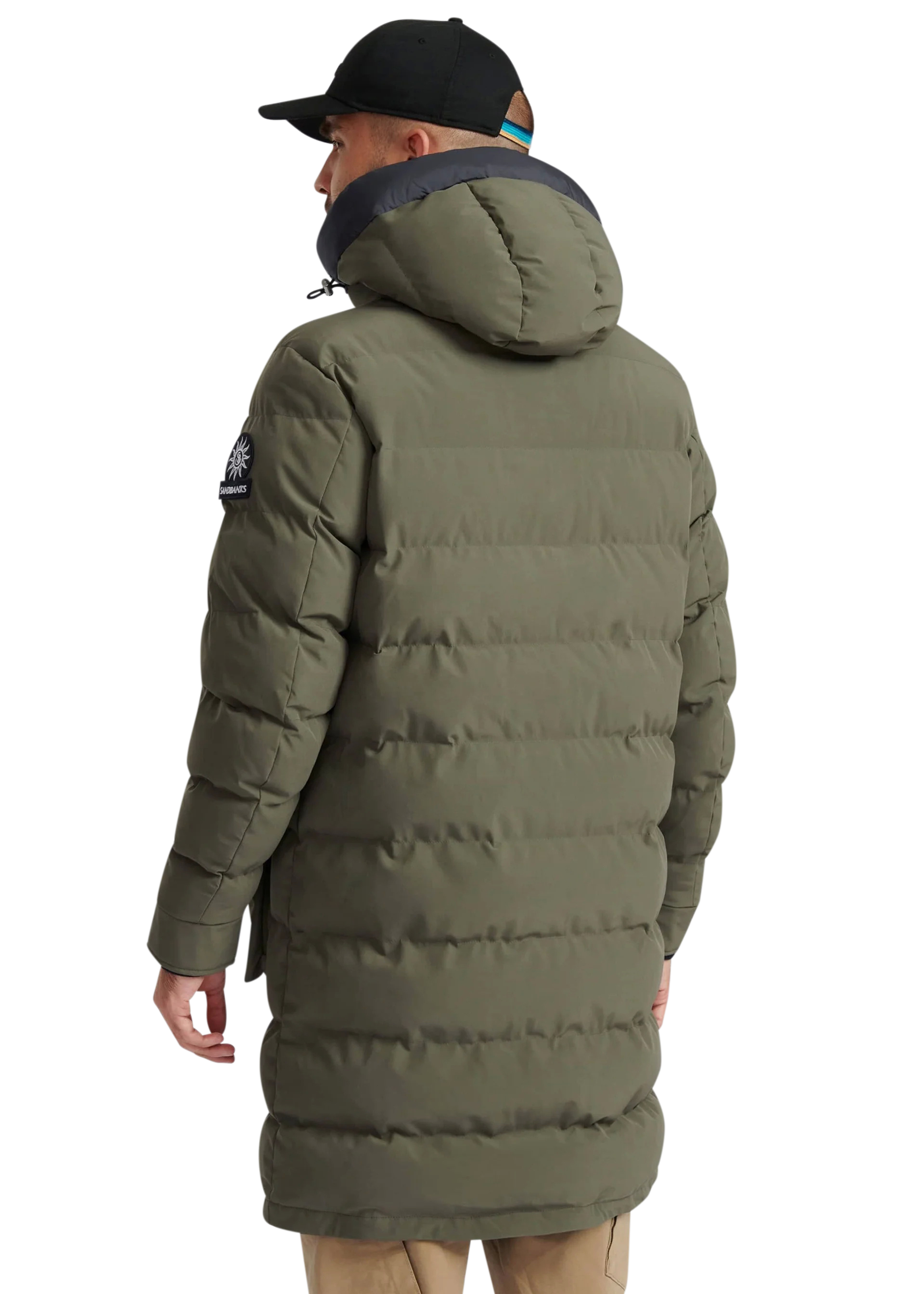 Person wearing a long green puffer coat on a white background