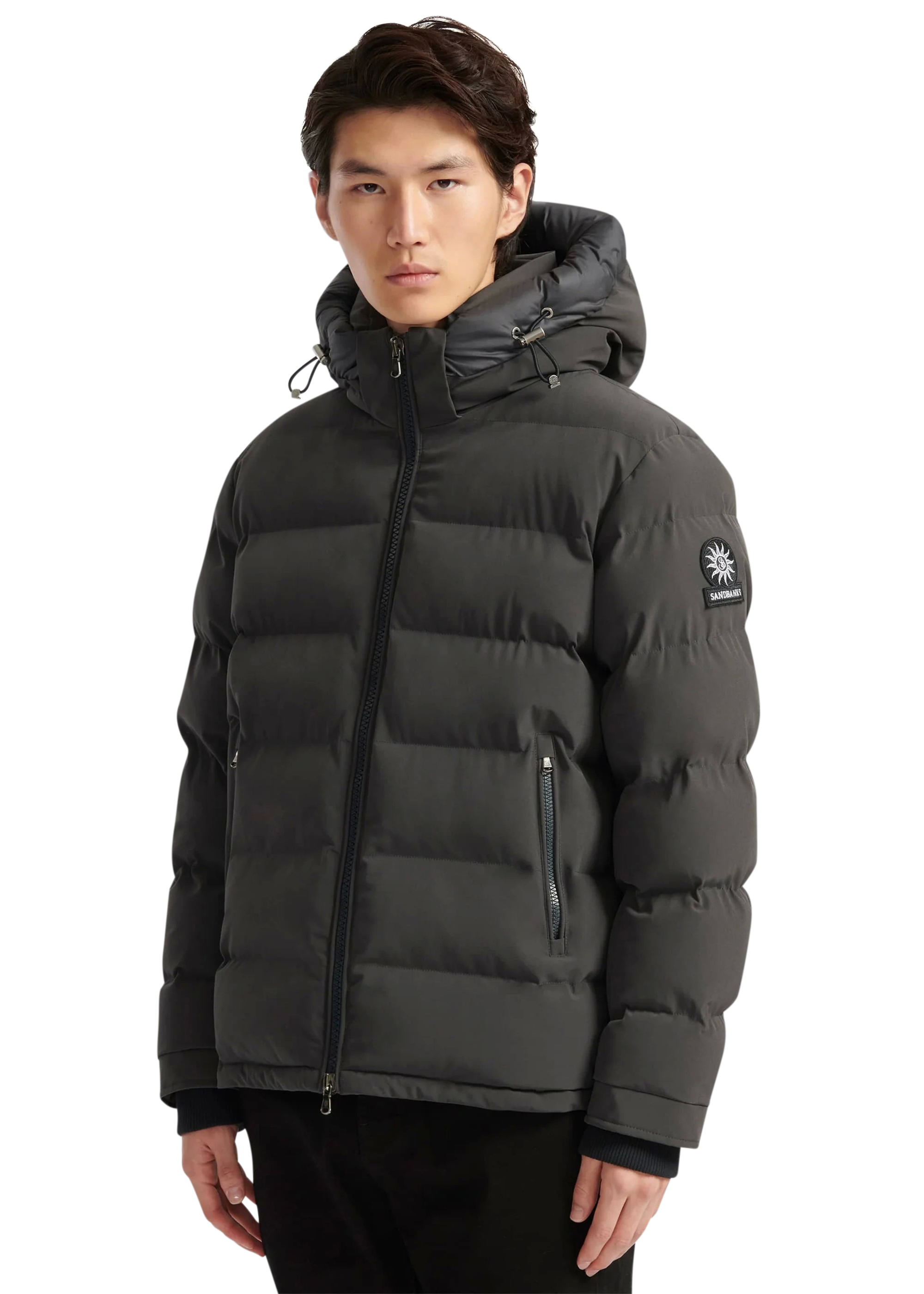 Man wearing a black puffer jacket with a brand logo on a white background