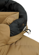 Close-up of a brown and black jacket with a hood on a white background
