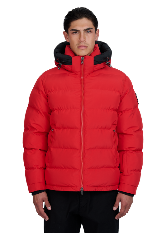 Man wearing a red puffer jacket with black accents on a white background