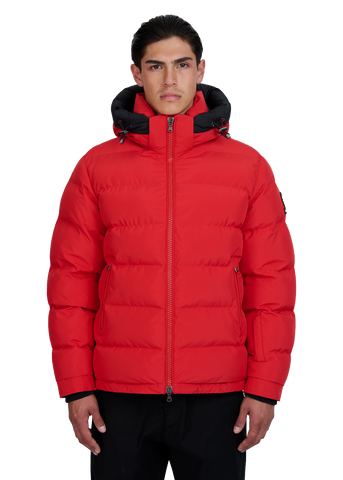 Man wearing a red puffer jacket with black accents on a white background
