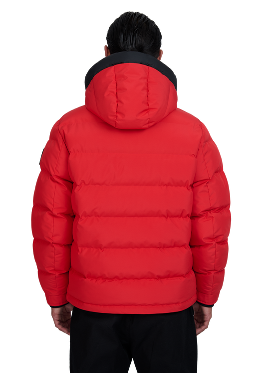 Red puffer jacket with black trim worn by a person on a white background