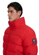 Man wearing a red puffer jacket with a brand logo on a white background