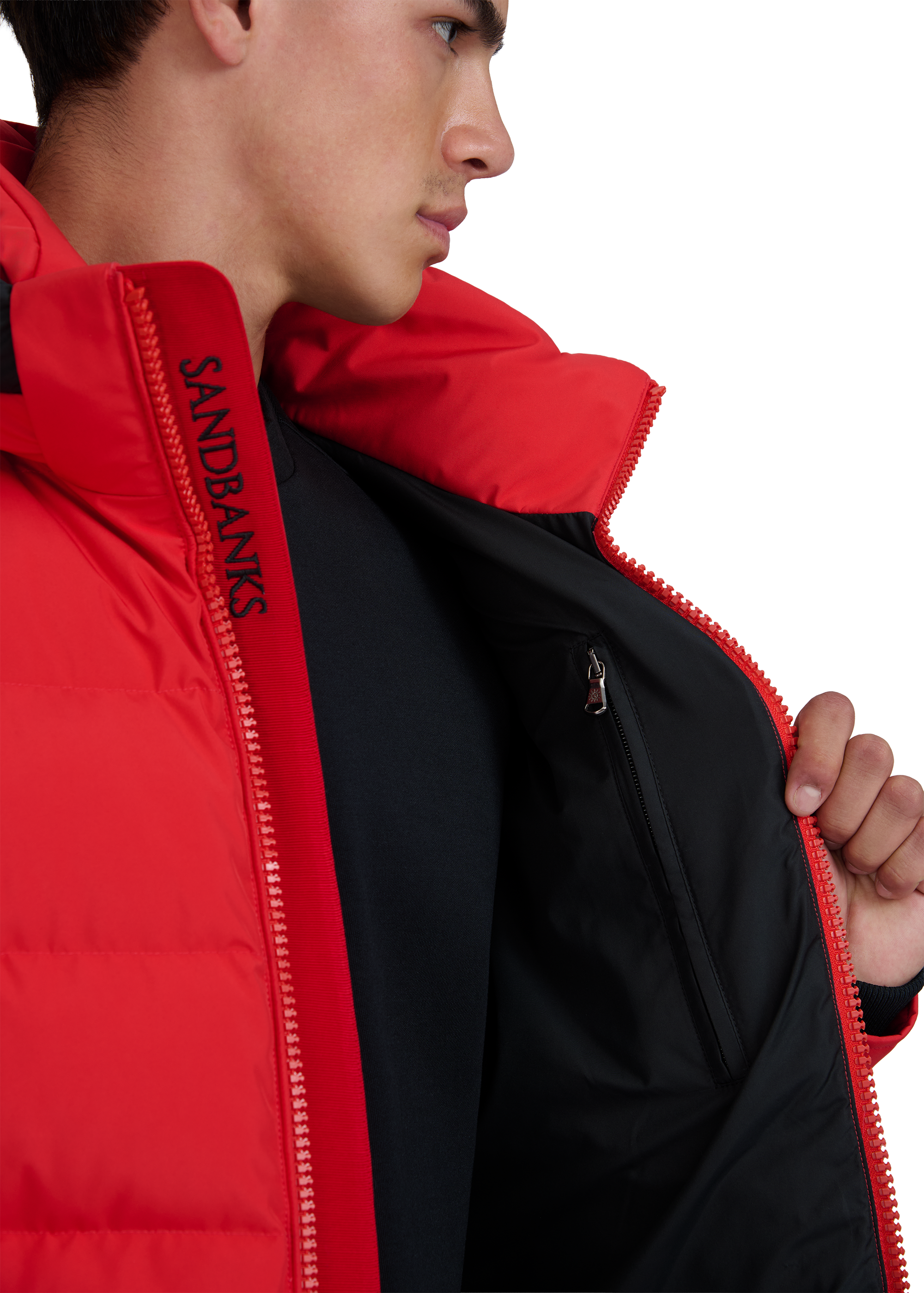 Person wearing a red jacket with 'Sandbanks' branding on a white background