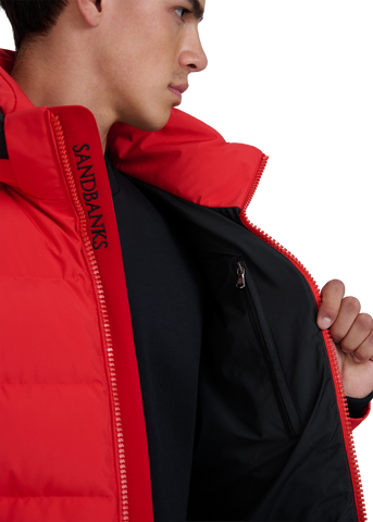 Person wearing a red jacket with 'Sandbanks' branding on a white background