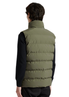 Person wearing a green puffer vest over a black shirt on a white background