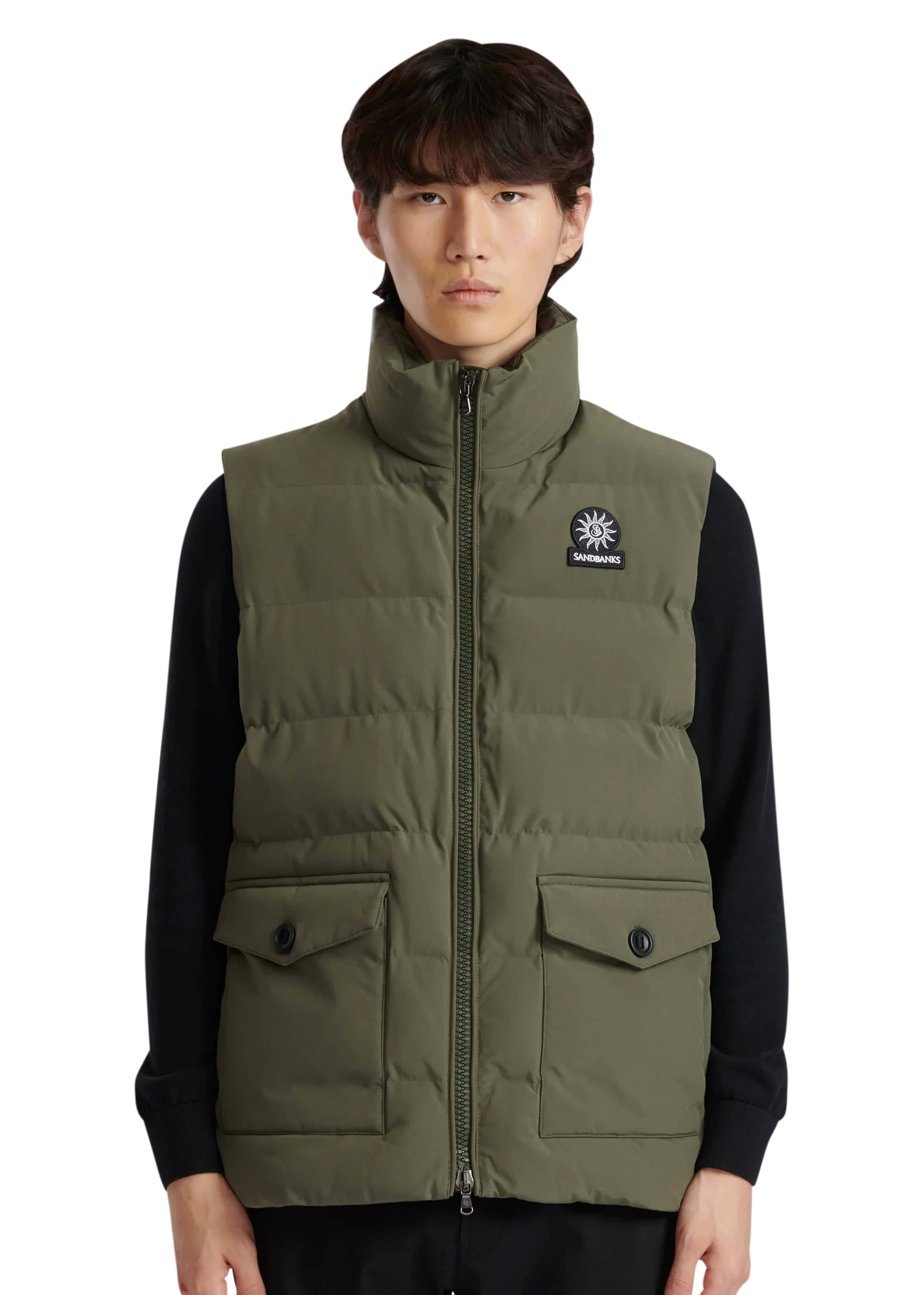 Person wearing a green puffer vest with a brand logo on a white background