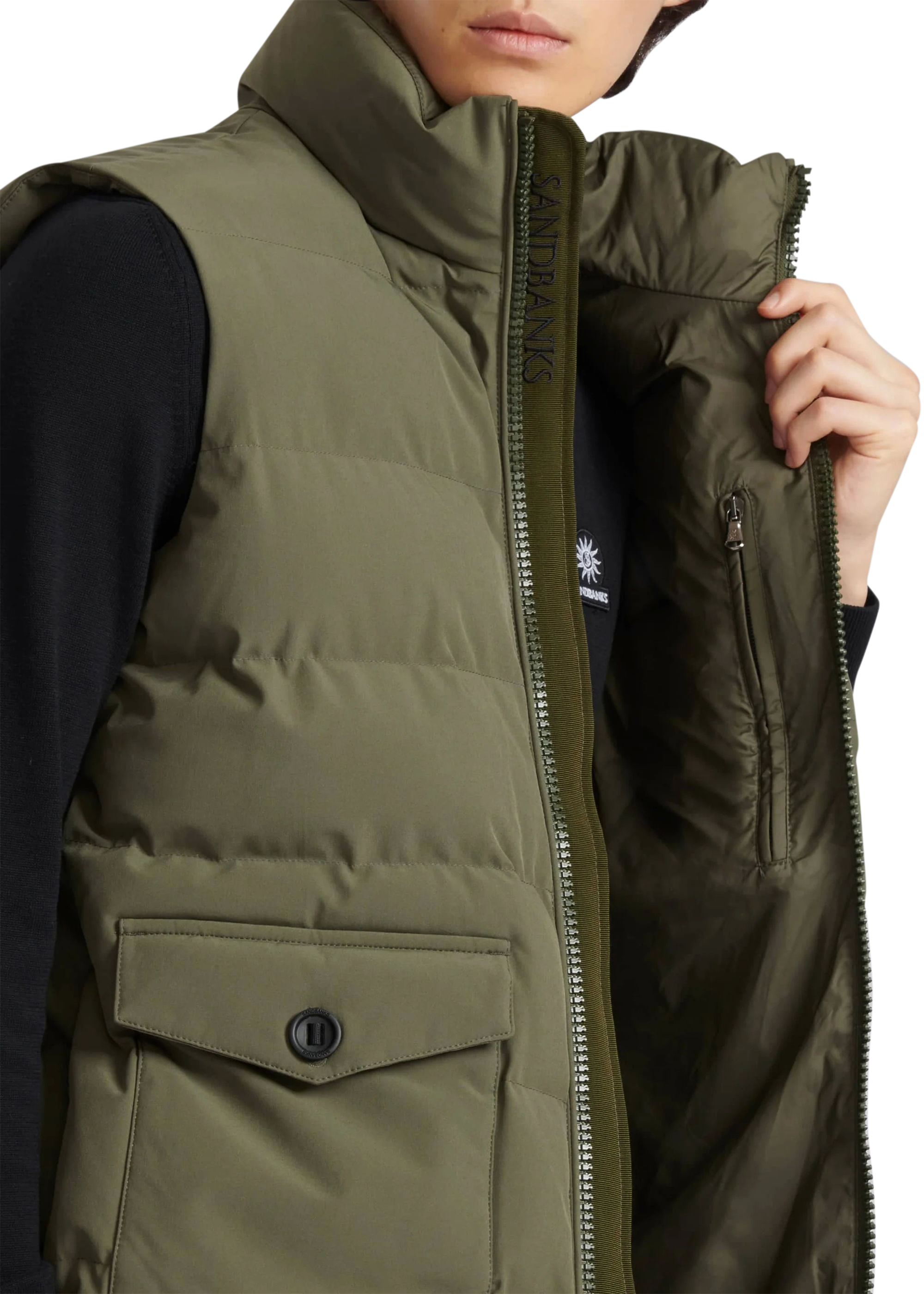 Person wearing a green puffer vest with a white background