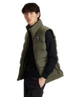 Man wearing a green puffer vest with a logo on a white background