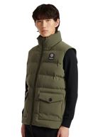 Person wearing a green puffer vest with a brand logo on a white background