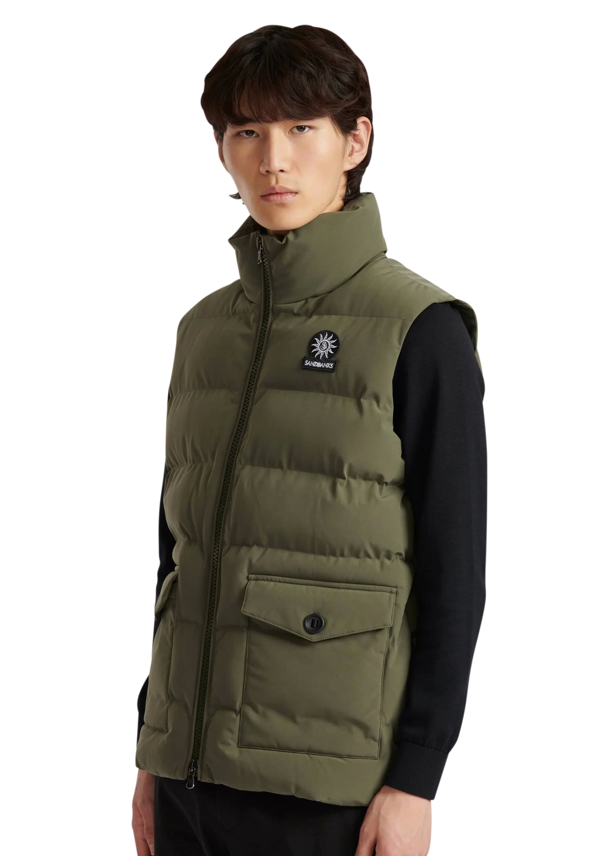 Person wearing a green puffer vest with a brand logo on a white background