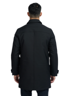 Man wearing a black coat from behind on a white background
