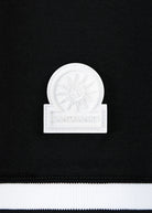 White decorative item with 'Sandbanks' branding on a black background