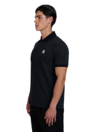 Model wearing a black patterned polo shirt with a logo on a white background