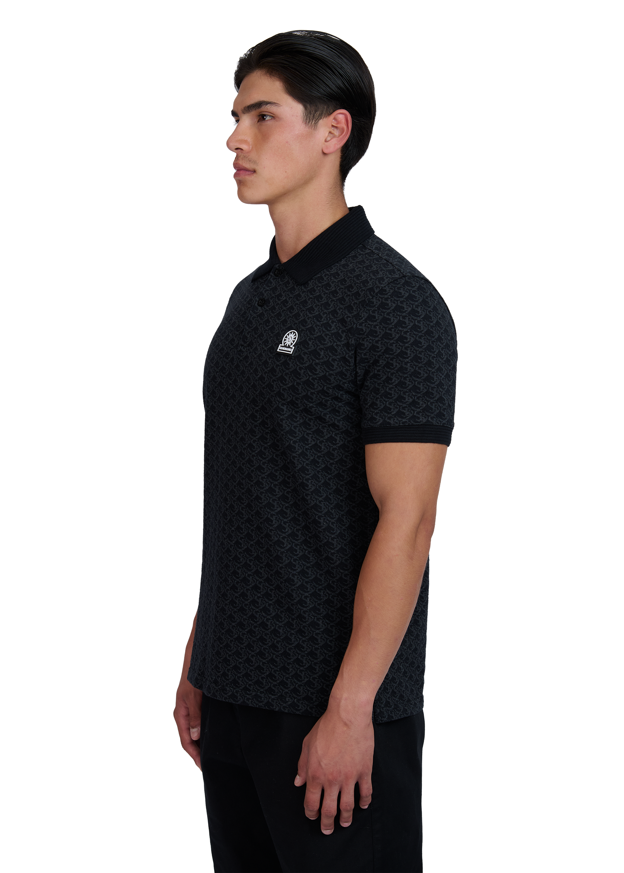 Model wearing a black patterned polo shirt with a logo on a white background