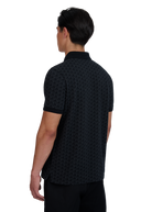 Model wearing a black patterned polo shirt on a white background