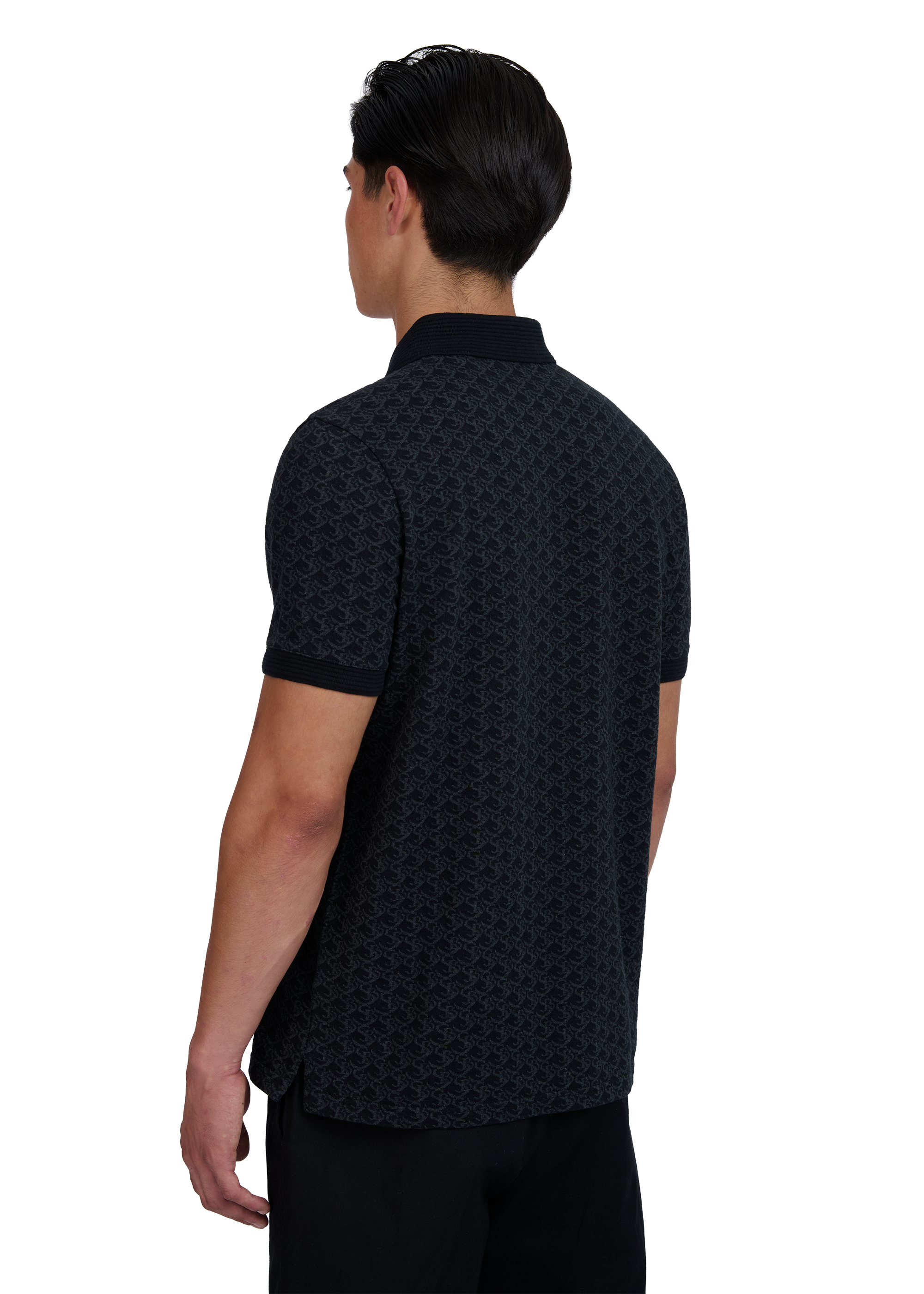 Model wearing a black patterned polo shirt on a white background