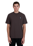 Model wearing a dark brown t-shirt with a logo on a white background