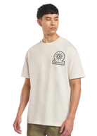 Model wearing a beige t-shirt with a logo on a white background