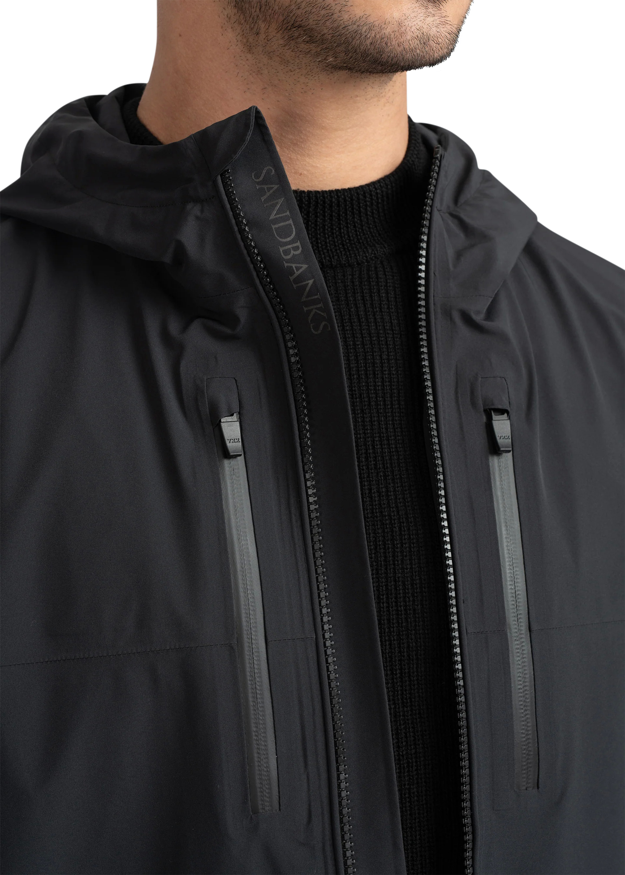 Close-up of a black jacket with a brand logo on a white background