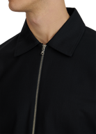 Close-up of a black jacket with a zipper on a white background