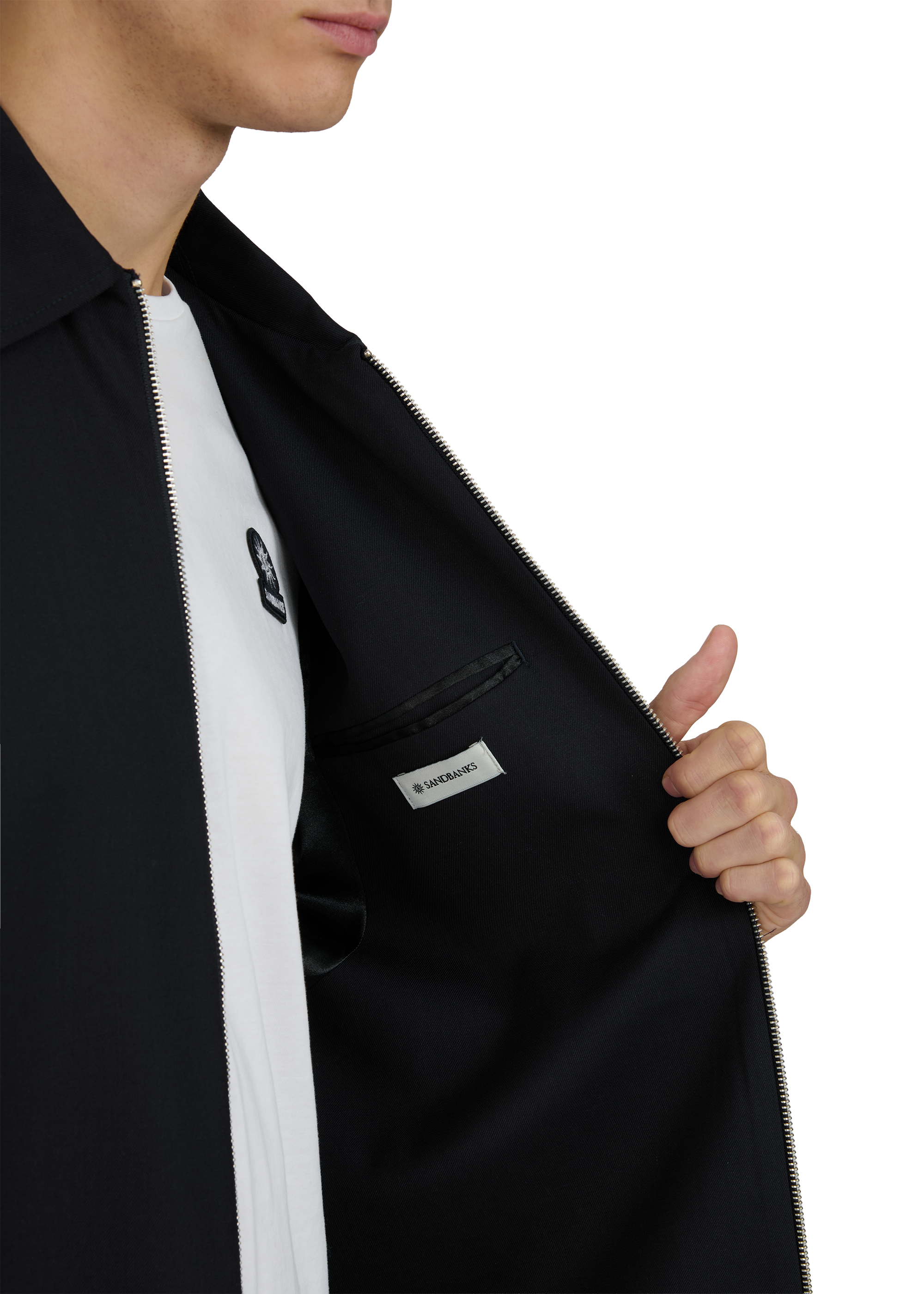 Person wearing a black jacket with a visible brand logo on a white background