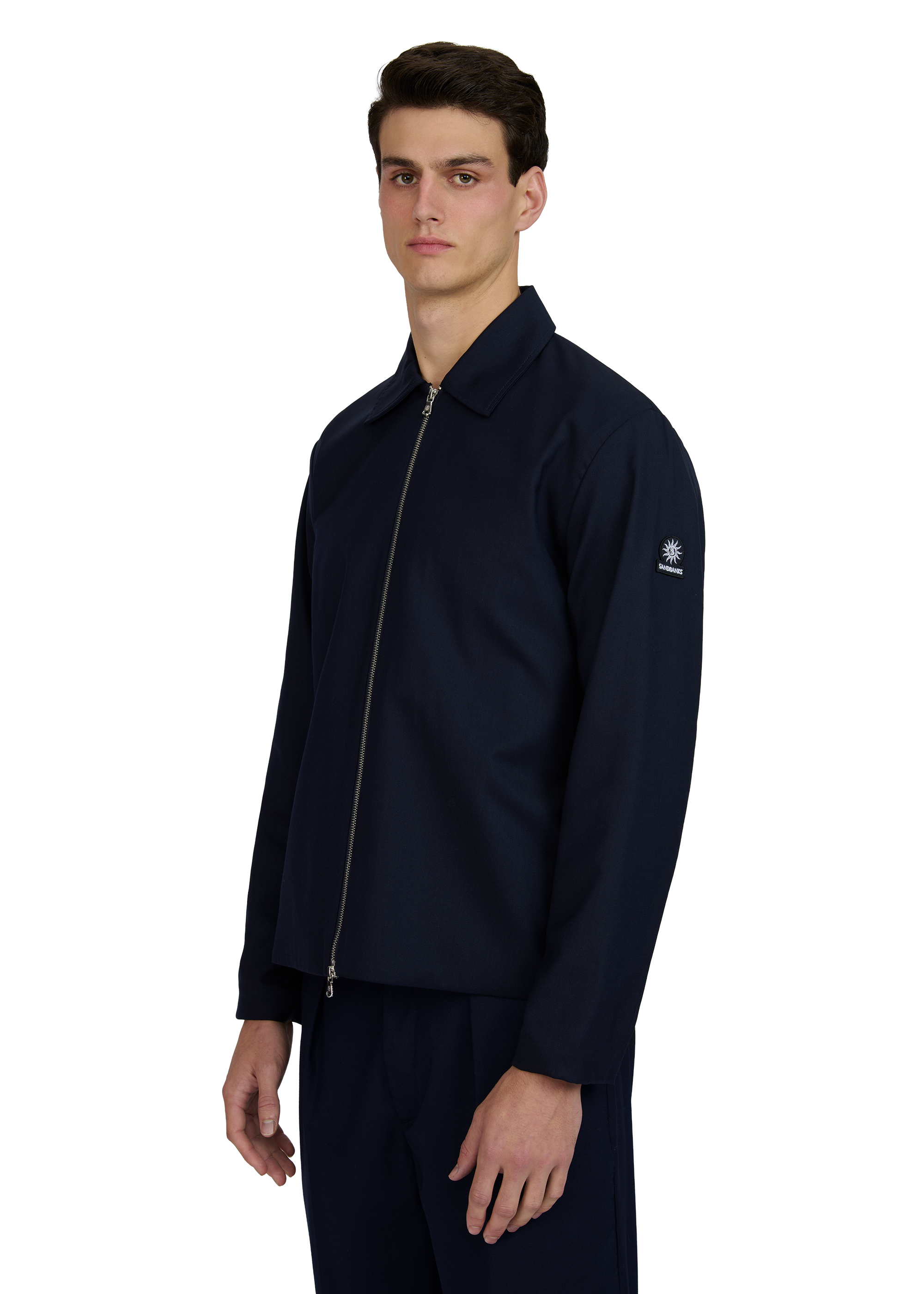 Man wearing a navy blue jacket with a brand logo on a white background